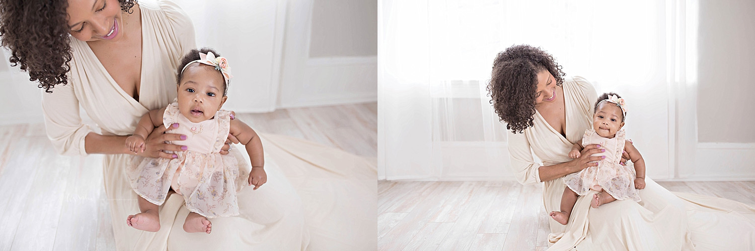  Image of an African American mother, sitting on the floor smiling down at her 6 month old baby, daughter on lap.&nbsp; 