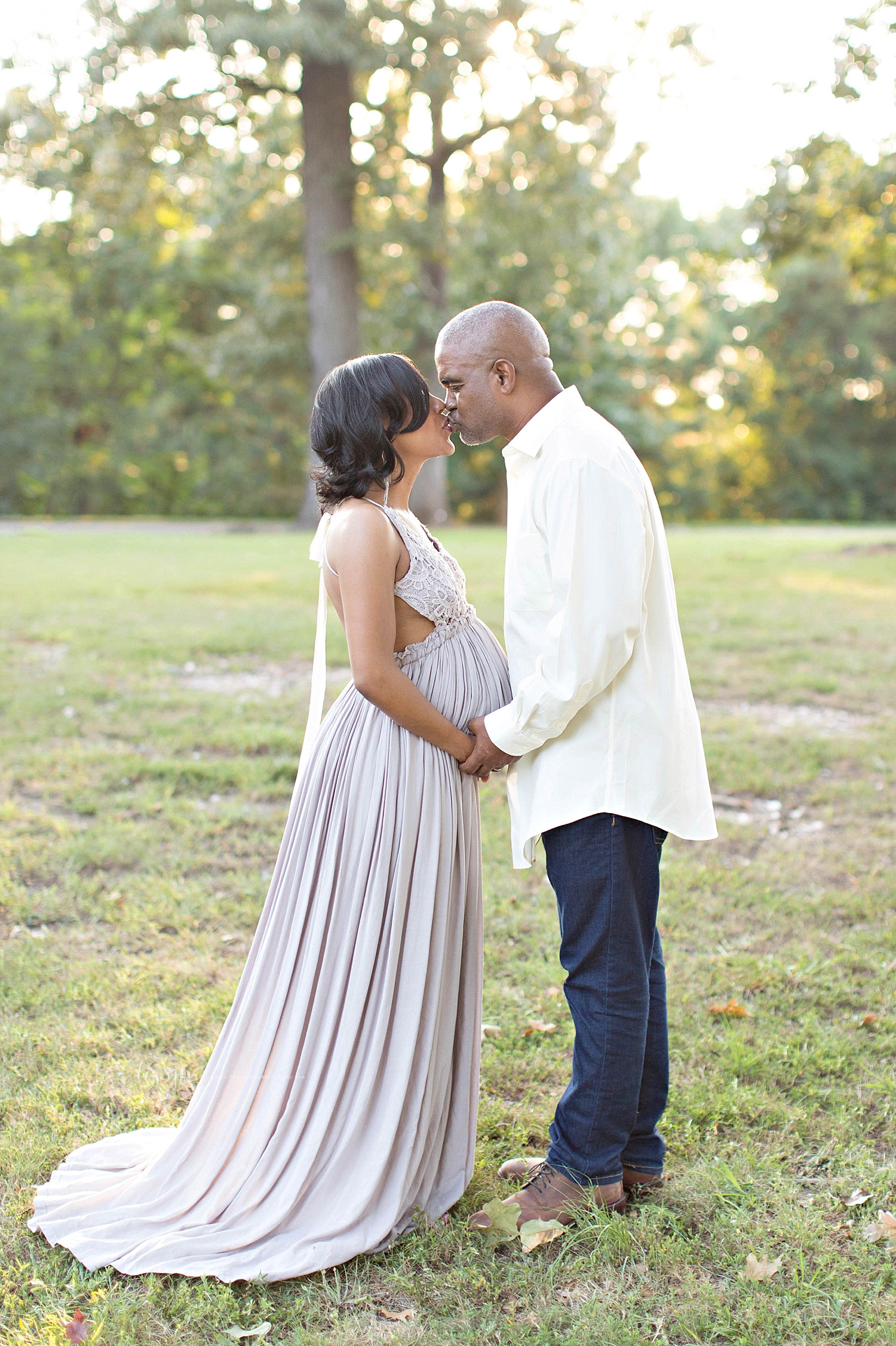  Image of a pregnant, African American woman, and her husband, facing each other, holding hands and kissing.&nbsp; 