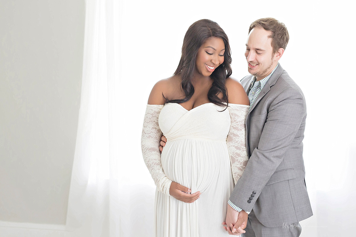  Image of a pregnant African American woman, and her Caucasian husband, standing next to each other and smiling.&nbsp; 