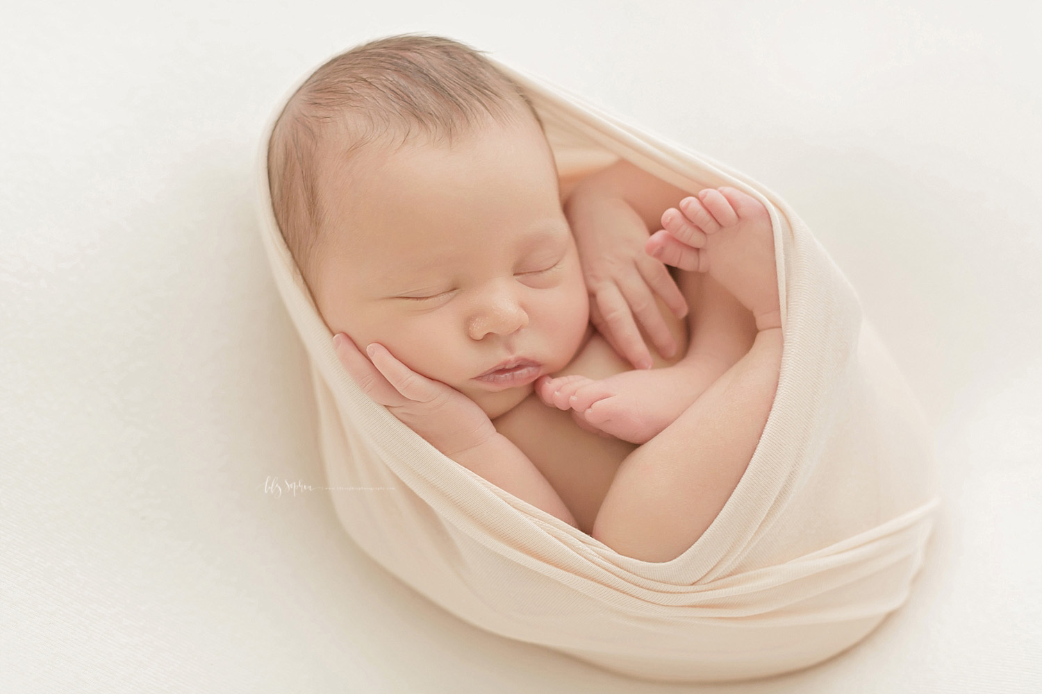 Image of a sleeping, newborn, baby, girl, in the egg pose.&nbsp; 