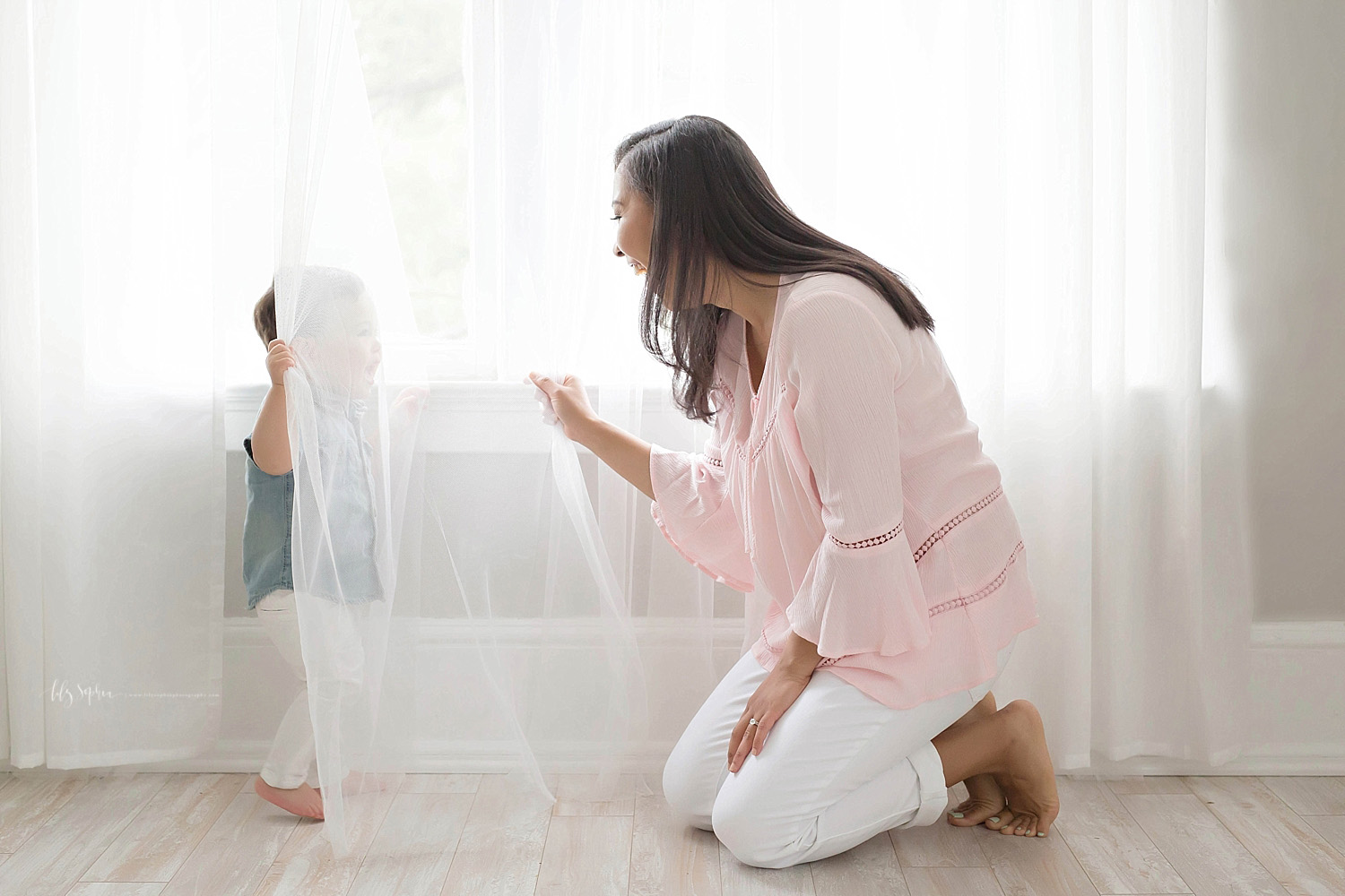  Image toddler boy, hiding behind a curtain and laughing while his mother tries to find him.&nbsp; 