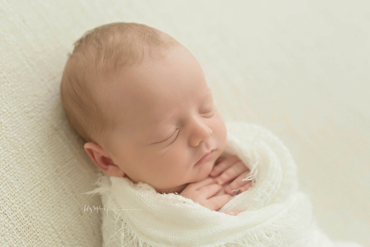  Image of a sleeping, baby, newborn boy. with his hands on his chest, wrapped in a blanket.&nbsp; 