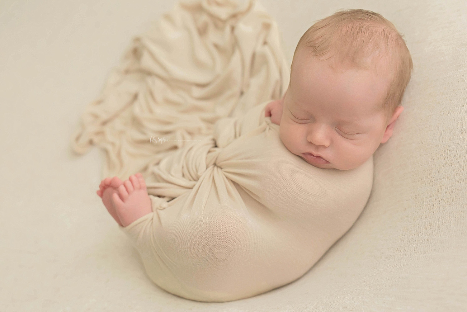  Image of a sleeping, baby, newborn, boy, with wrapped up with just his toes and finger sticking out.&nbsp; 