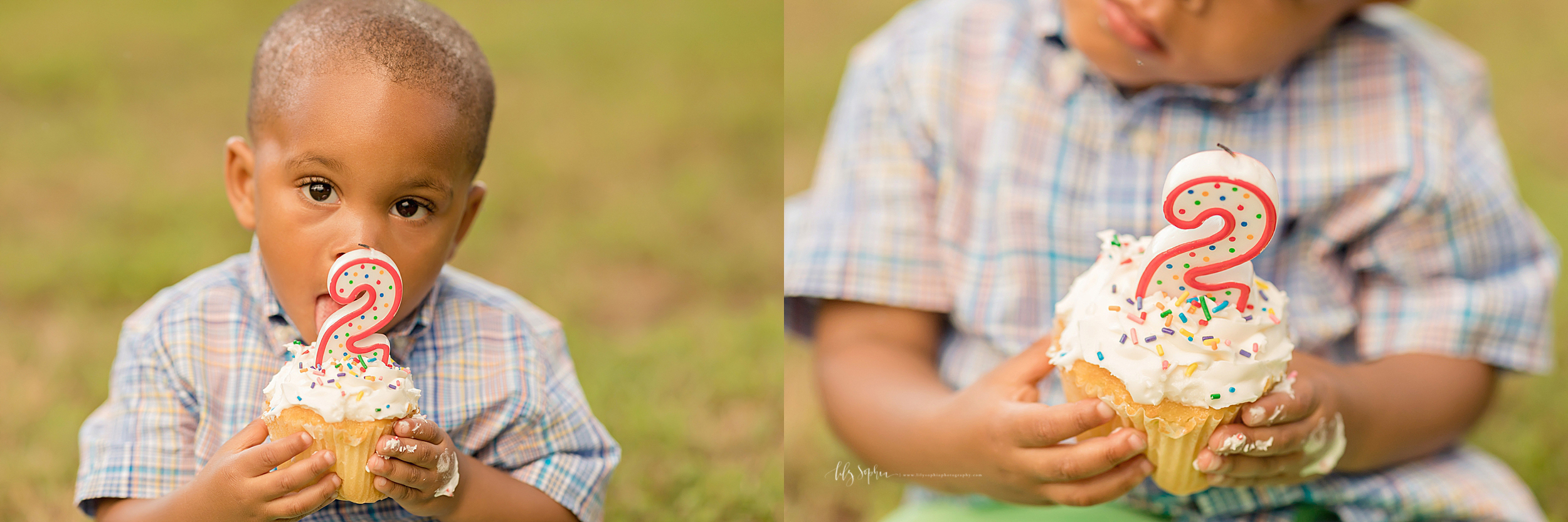  Cute African American two year old eating his birthday cupcake in the park.  He is holding the vanilla cupcake with white icing and a red outlined number two polka dotted candle on top in both his hands.  His tiny left hand has icing on it and he is