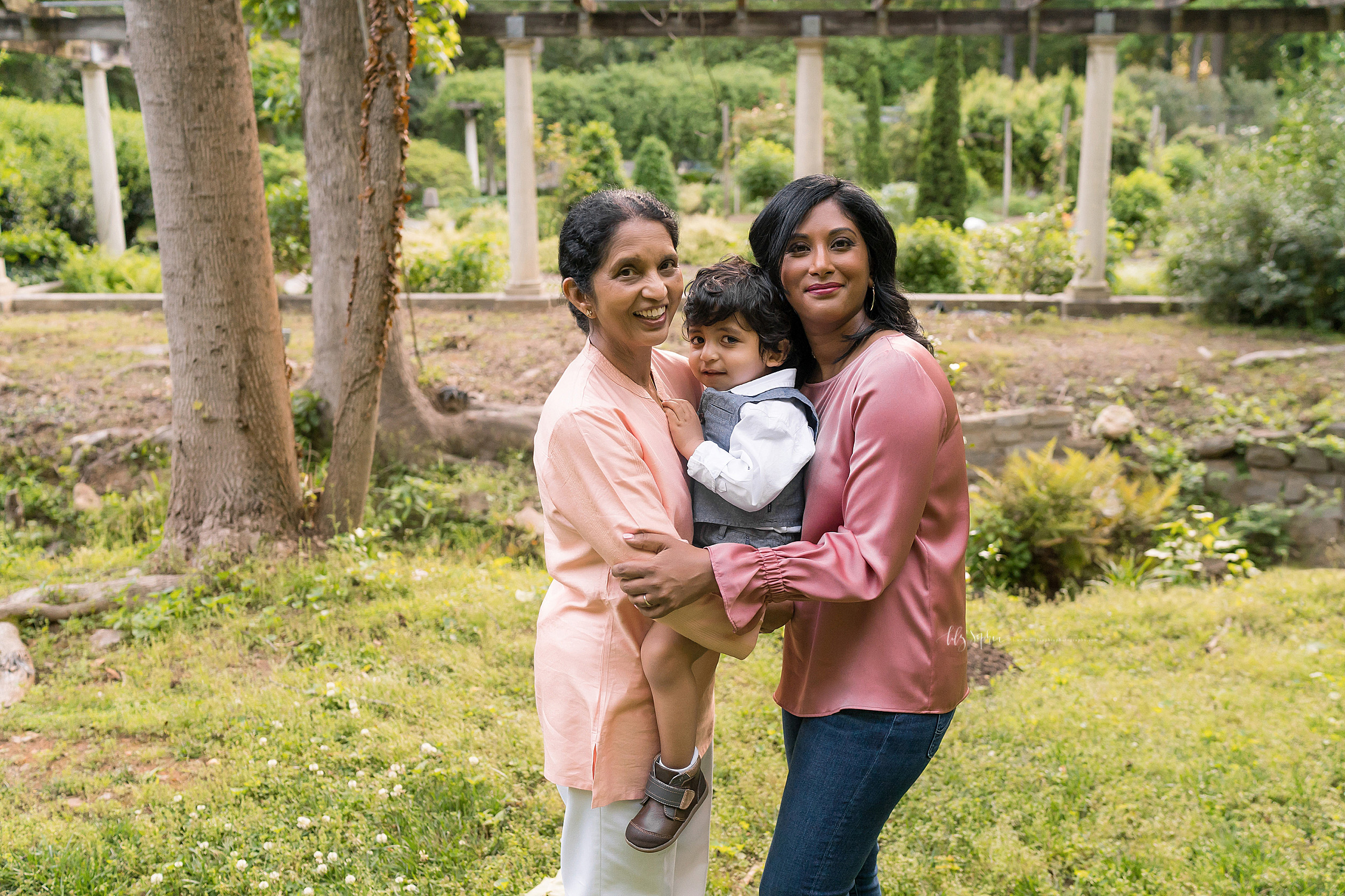  Generational photo of an Indian grandmother, daughter, and her toddler son at sunset in a garden in Atlanta. 