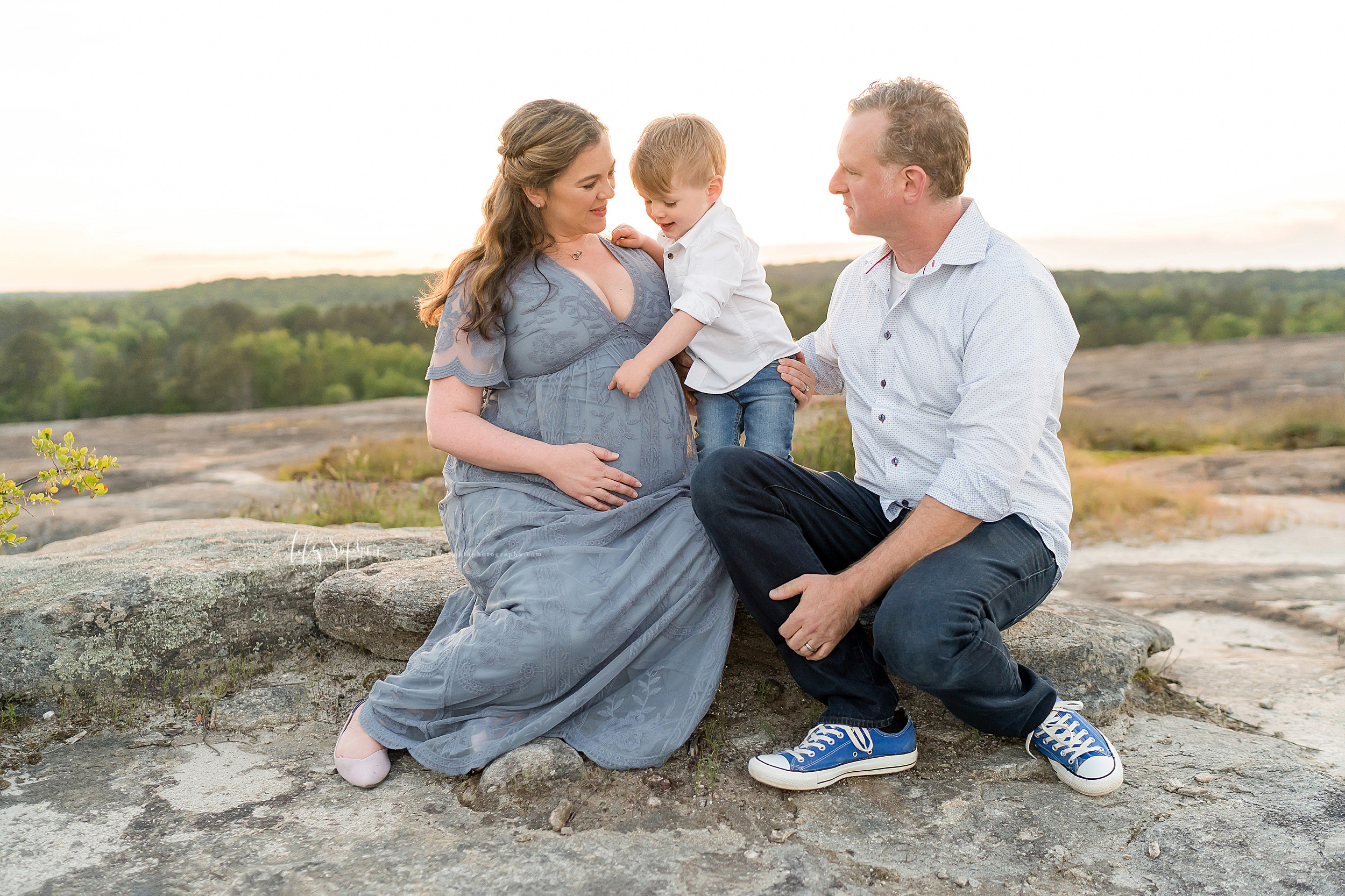  Family photo of three, soon-to-be four, on a mountaintop in Atlanta at sunset. 