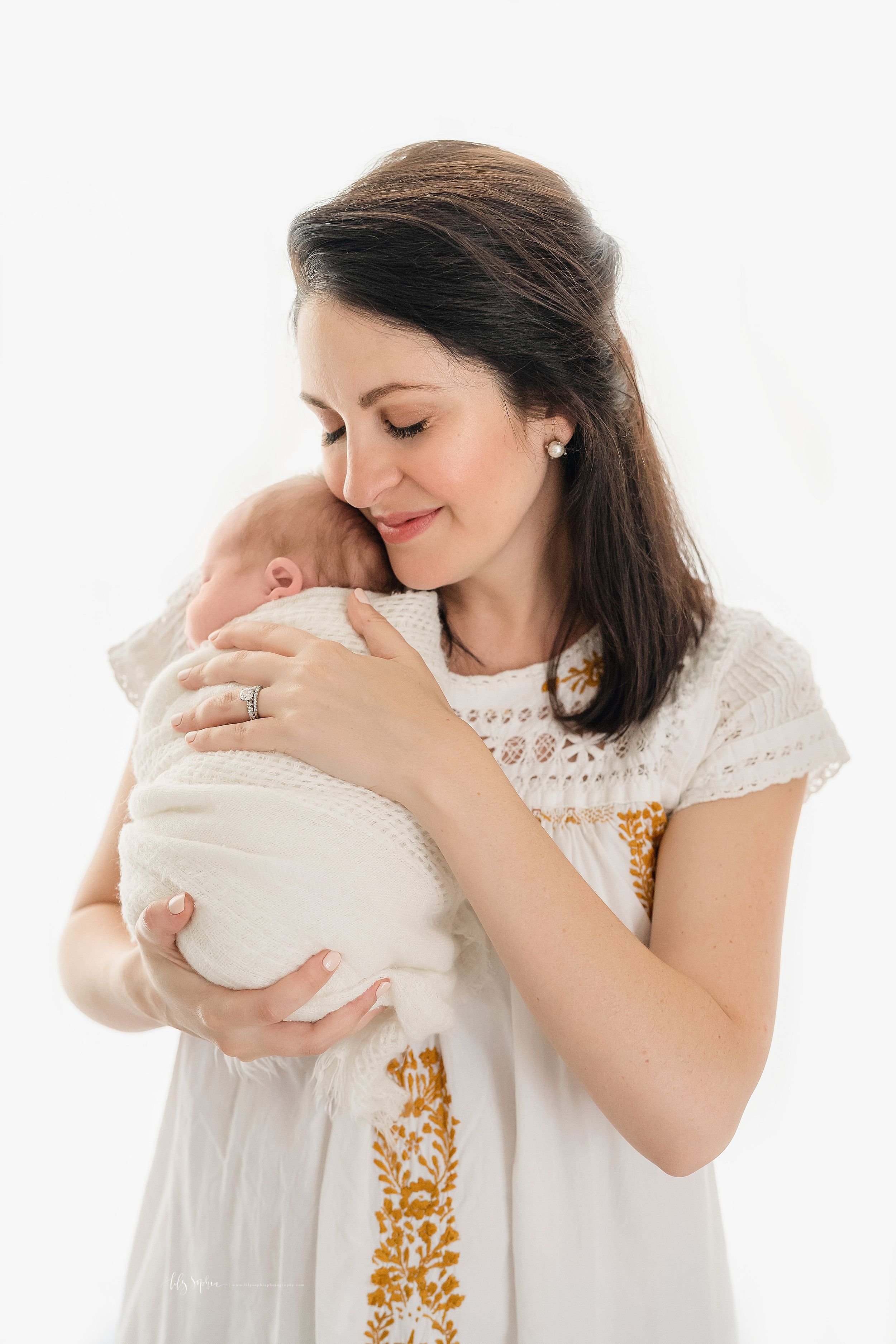  Photo of a contented mom and her sleeping newborn baby girl in natural light in an Atlanta studio. 