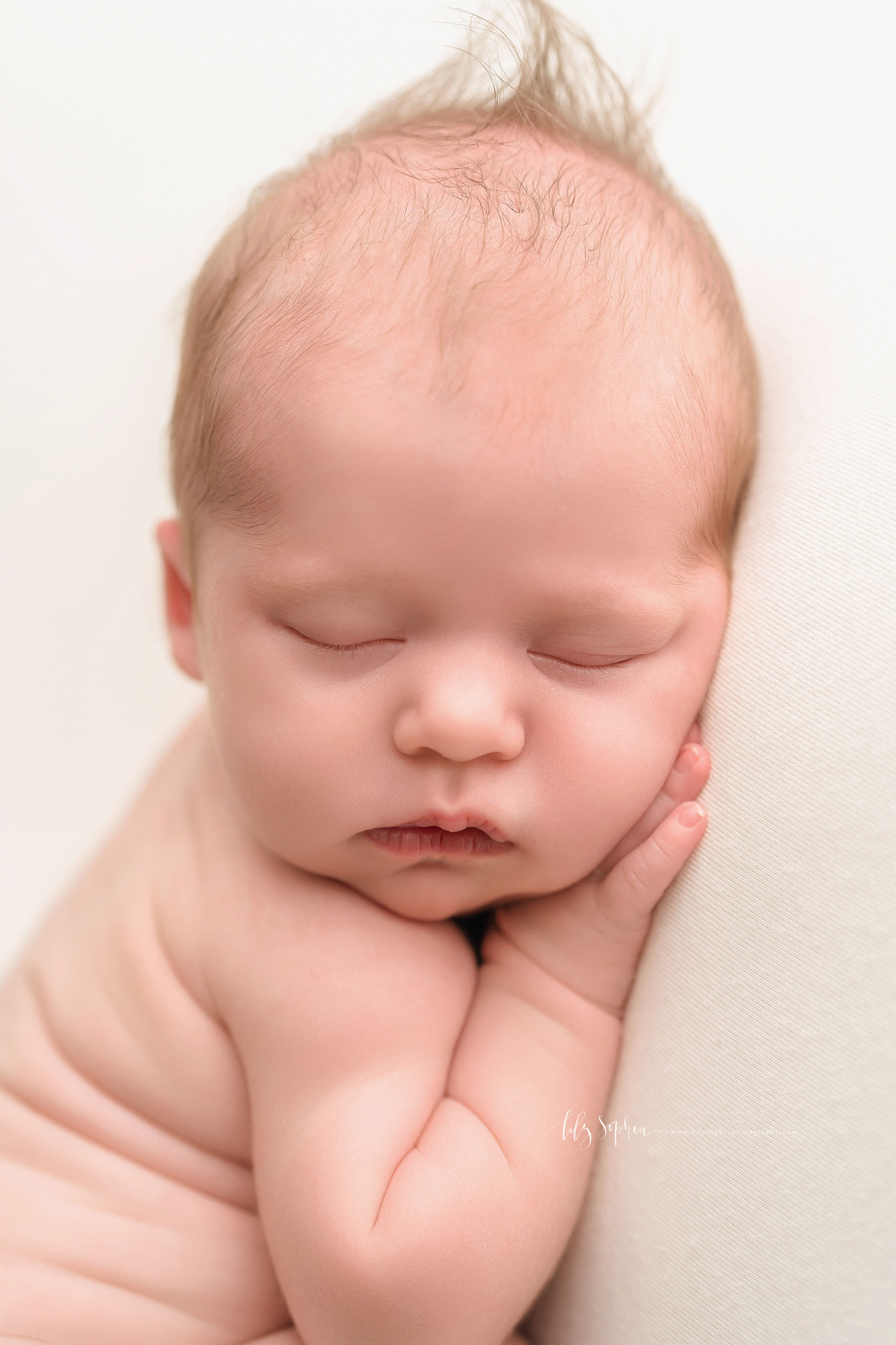  Precious close-up photo of a peacefully sleeping newborn baby girl taken in natural light in an Atlanta studio. 