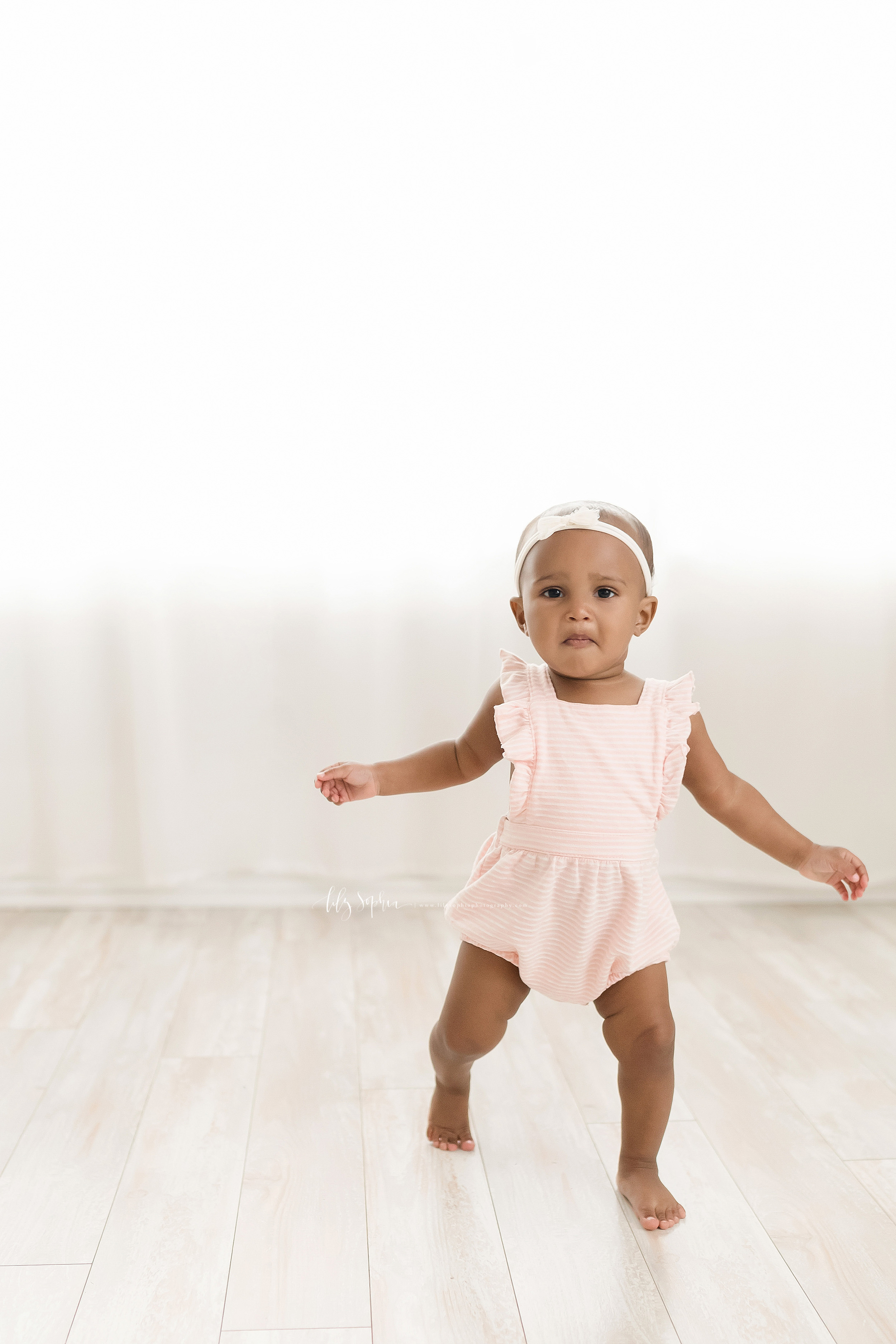  Milestone photo of an African-American baby girl walking on her own in a studio in Atlanta in natural light. 