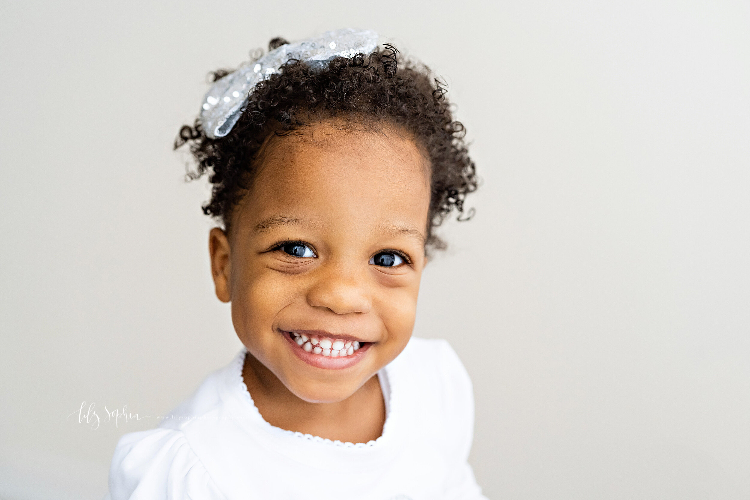  Milestone photo of a two year old African-American little girl as she smiles in a natural light studio in the Brookhaven area of Atlanta. 