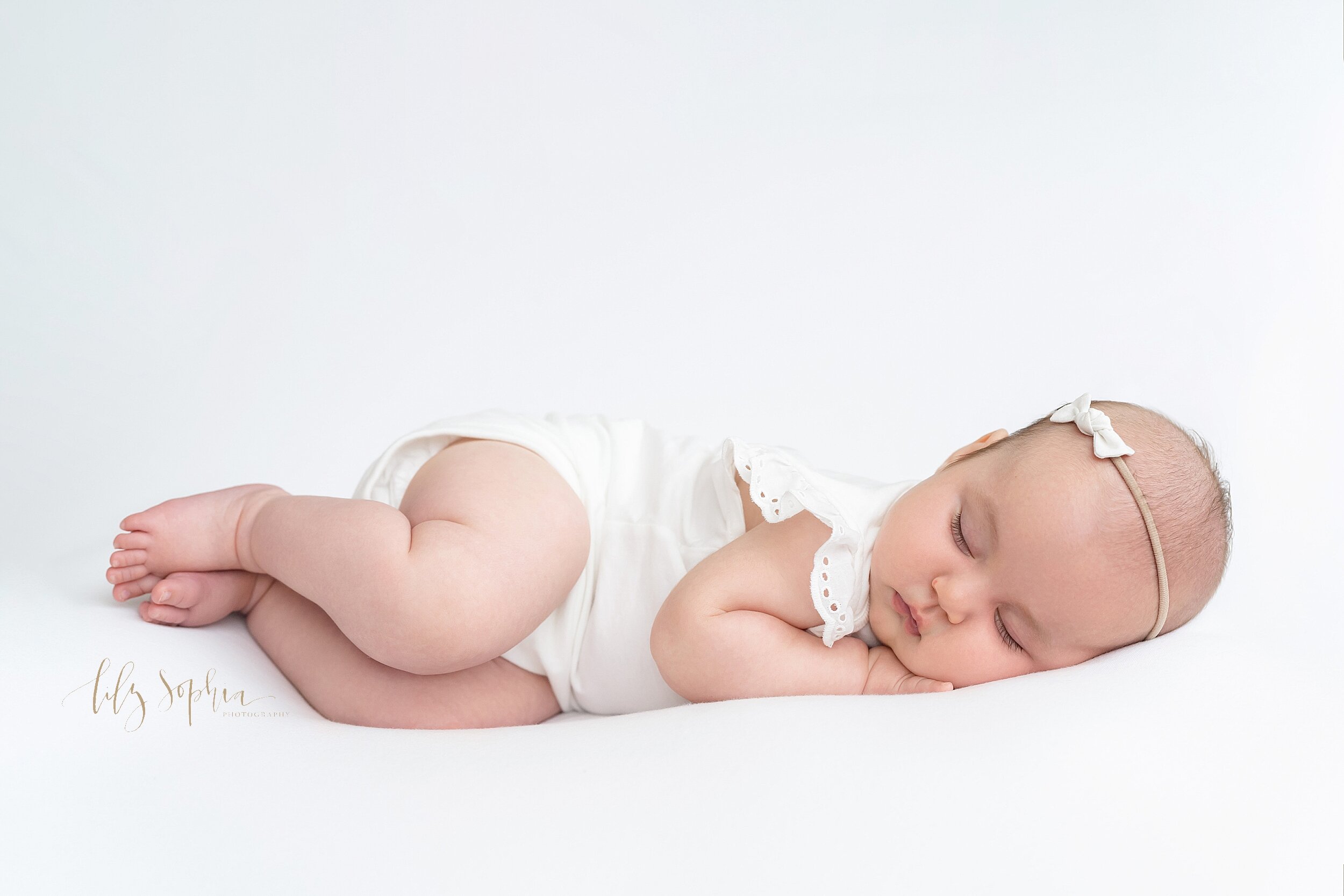  Baby picture of a three month old little girl as she sleeps on her side with her hand under her cheek taken in a studio near Poncey Highlands in Altanta in natural light. 