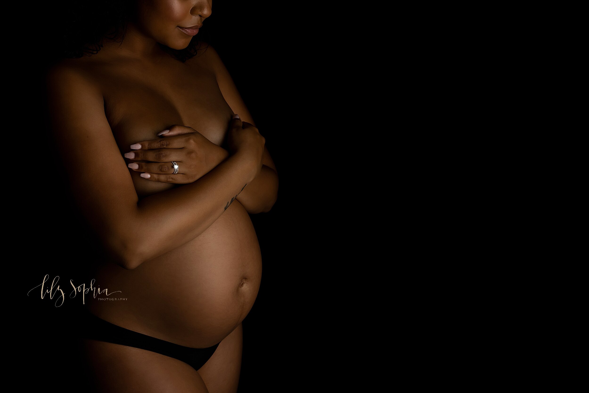  Atlanta, Georgia fine art modern maternity portrait of black pregnant woman looking down at her pregnant belly.  
