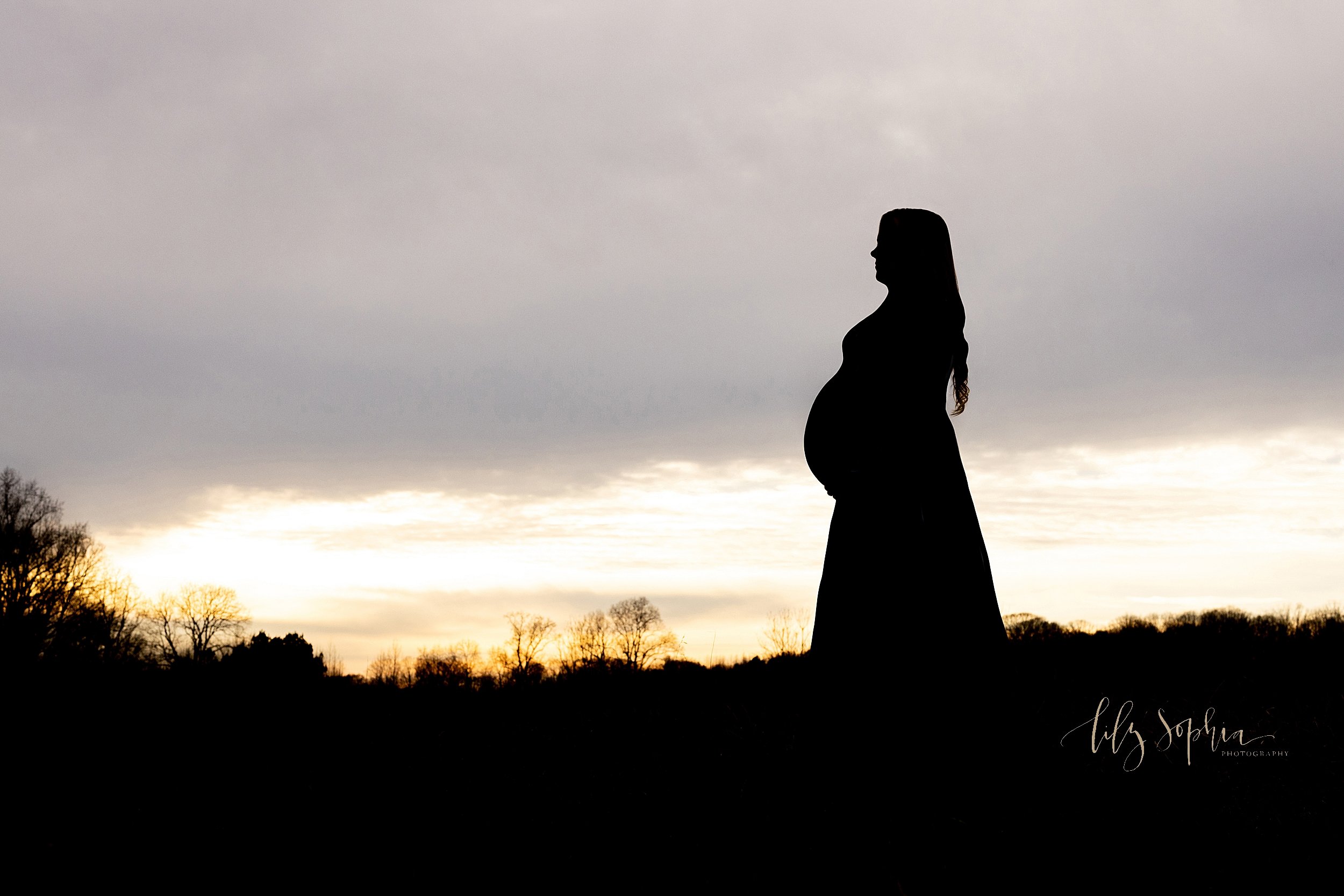  Silhouette maternity photo taken at sunset in a field near Atlanta, Georgia. 