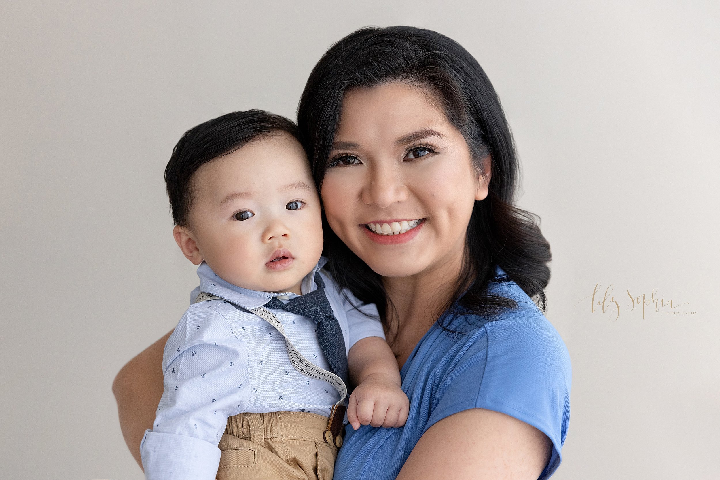 Family photo of an Asian mother holding her baby son in her arms taken near Smyrna in Atlanta in a natural light studio. 