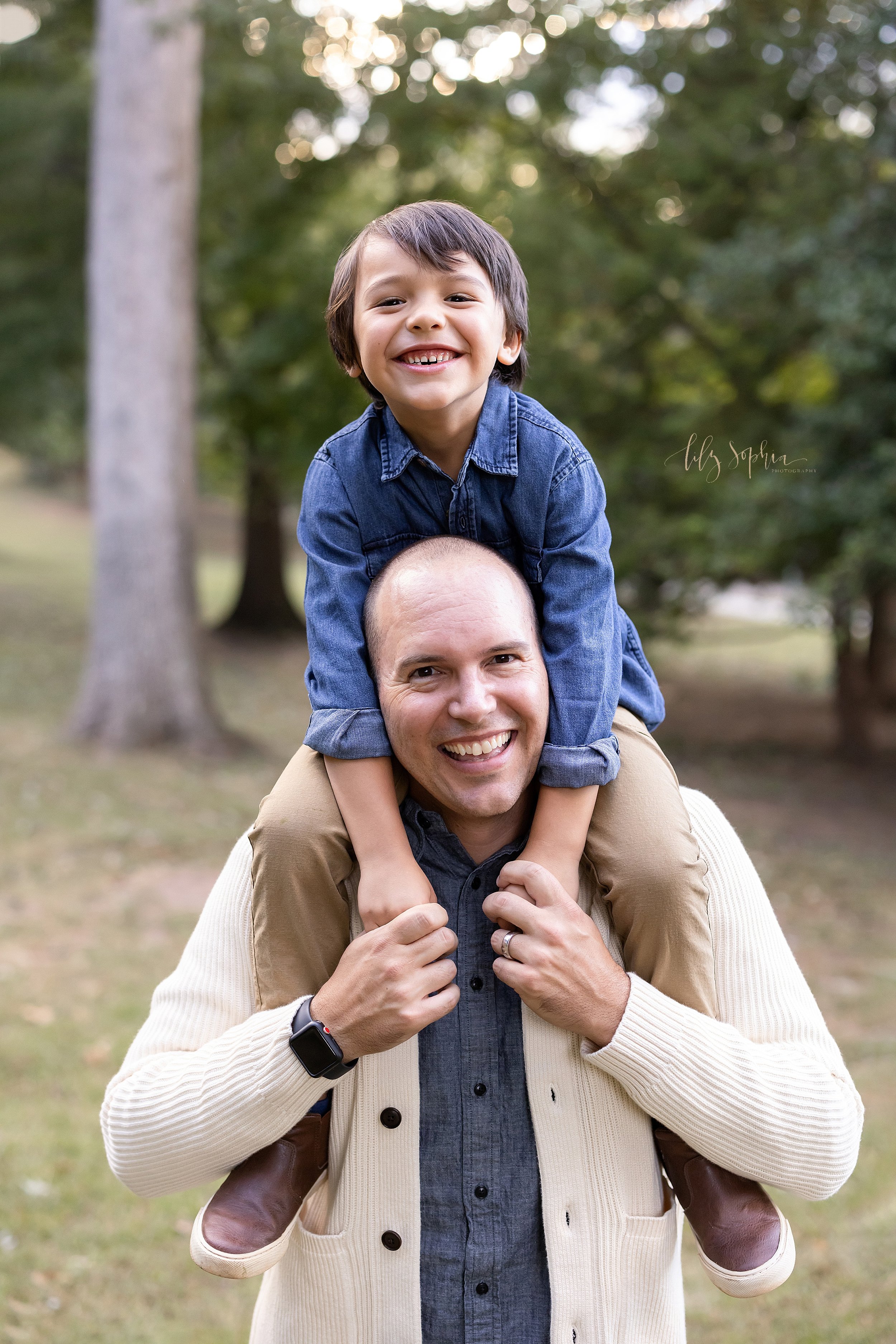  Family father son photo taken during autumn in an Atlanta park of a father carrying his son on his shoulders. 