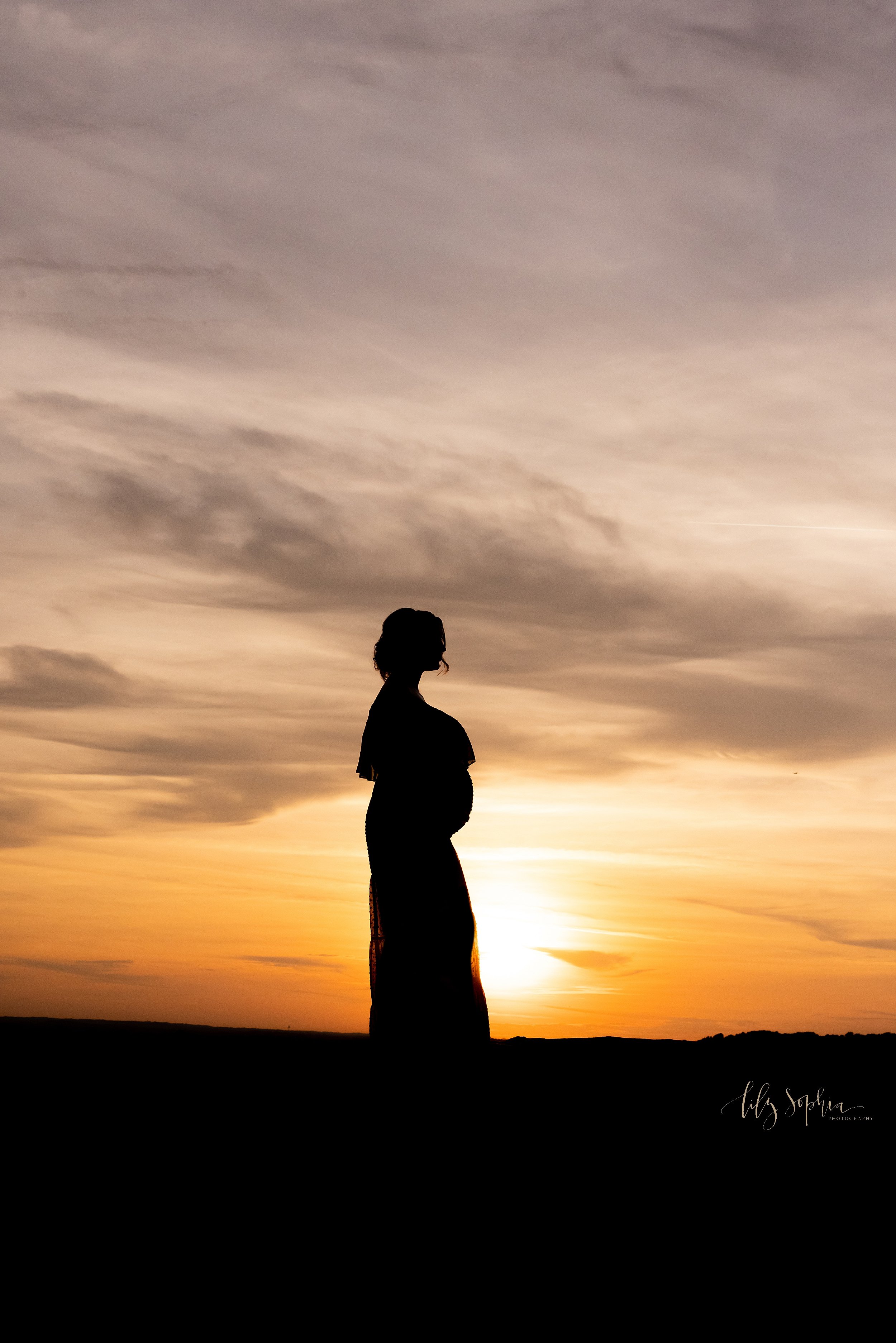  Silhouette maternity profile portrait of a mother-to-be taken on a mountain near Atlanta at sunset. 