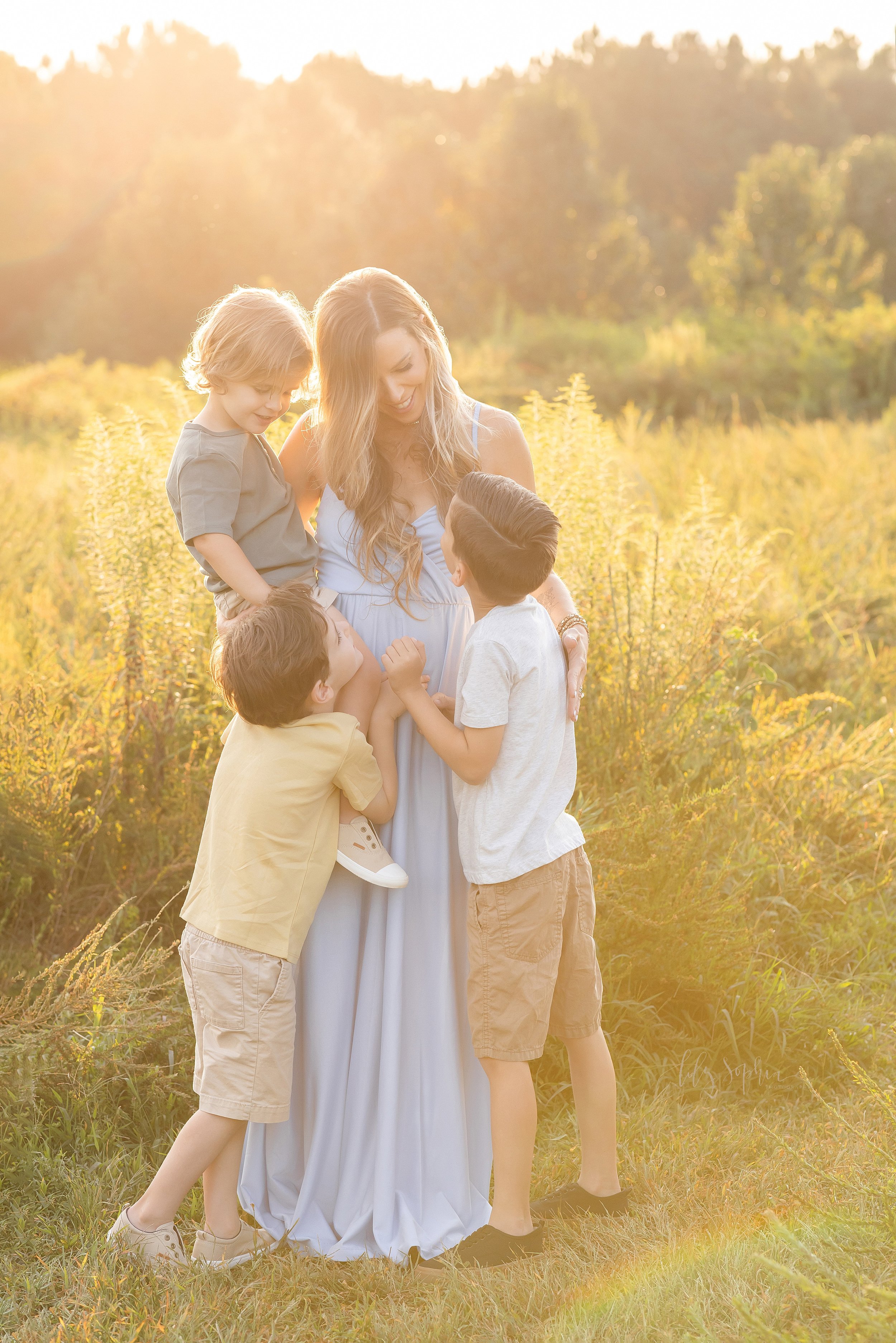  Family photo session in an Atlanta field at sunset with a mom and her three sons. 