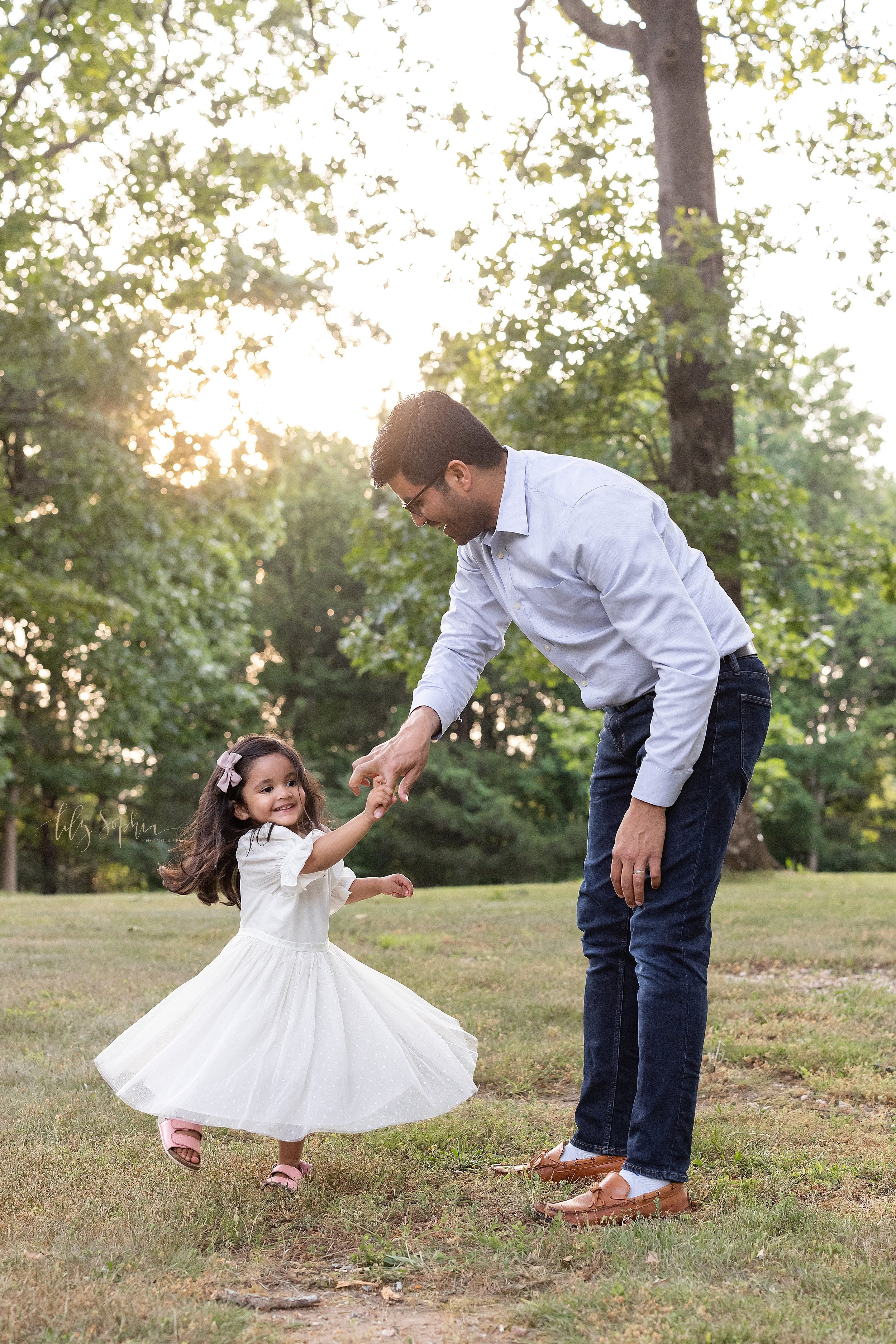  Family photo session of an Indian father dancing with his daughter at sunset in a park near Atlanta, Georgia. 