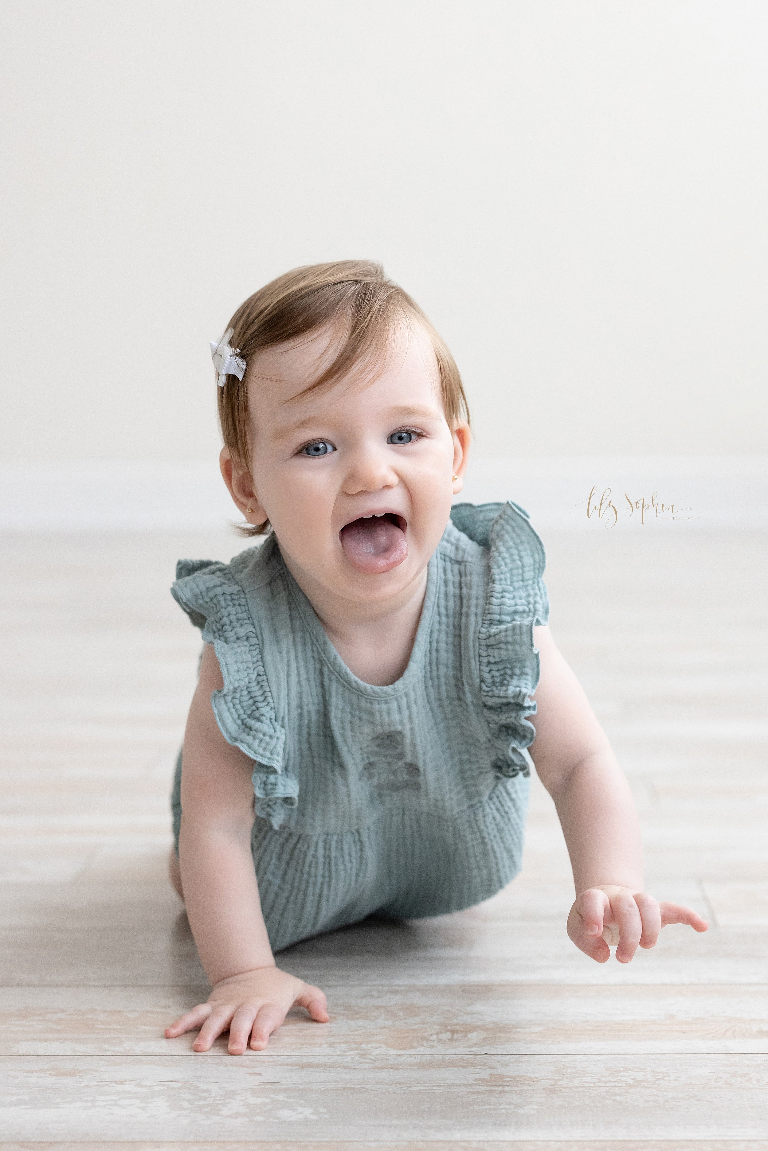  First birthday phot session of a one year old baby girl as she crawls across the floor of a natural light studio in Atlanta, Georgia. 