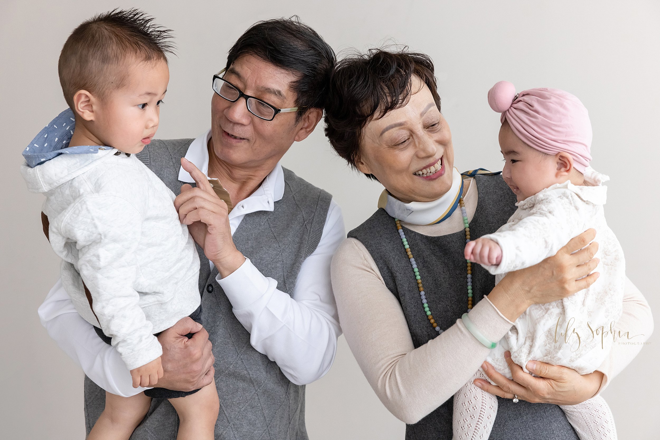  Family photo session with Asian grandparents holding their grandchildren taken in a natural light studio near Brookhaven in Atlanta, Georgia. 