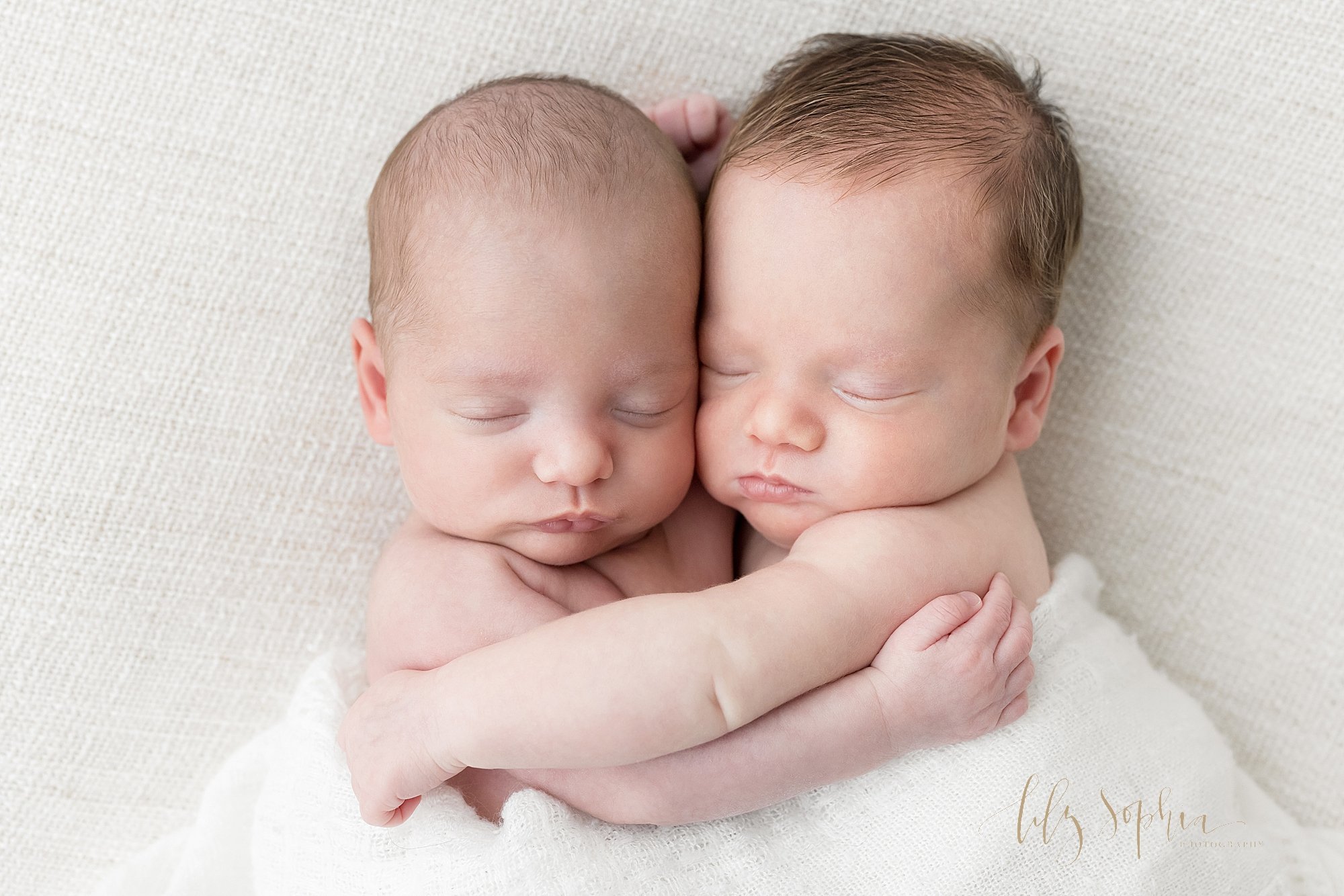  Newborn photo of twin brothers peacefully sleeping and hugging one another taken in a studio using natural light near Morningside in Atlanta, Georgia. 