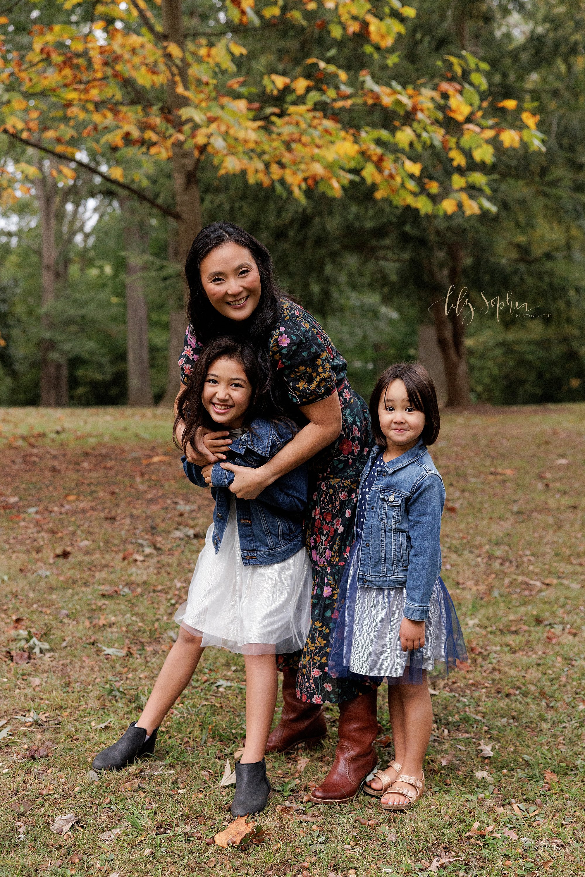  Family photo session with a mother and her two daughters at sunset in an Atlanta park at sunset during autumn. 