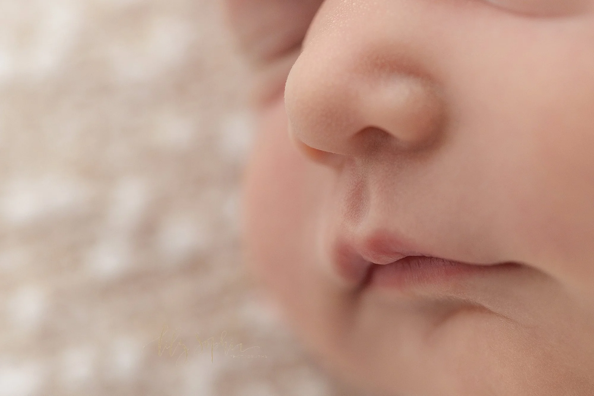  The button nose and lips of a newborn baby girl are featured in this close-up newborn picture taken in a natural light studio near Virginia Highlands in Atlanta. 