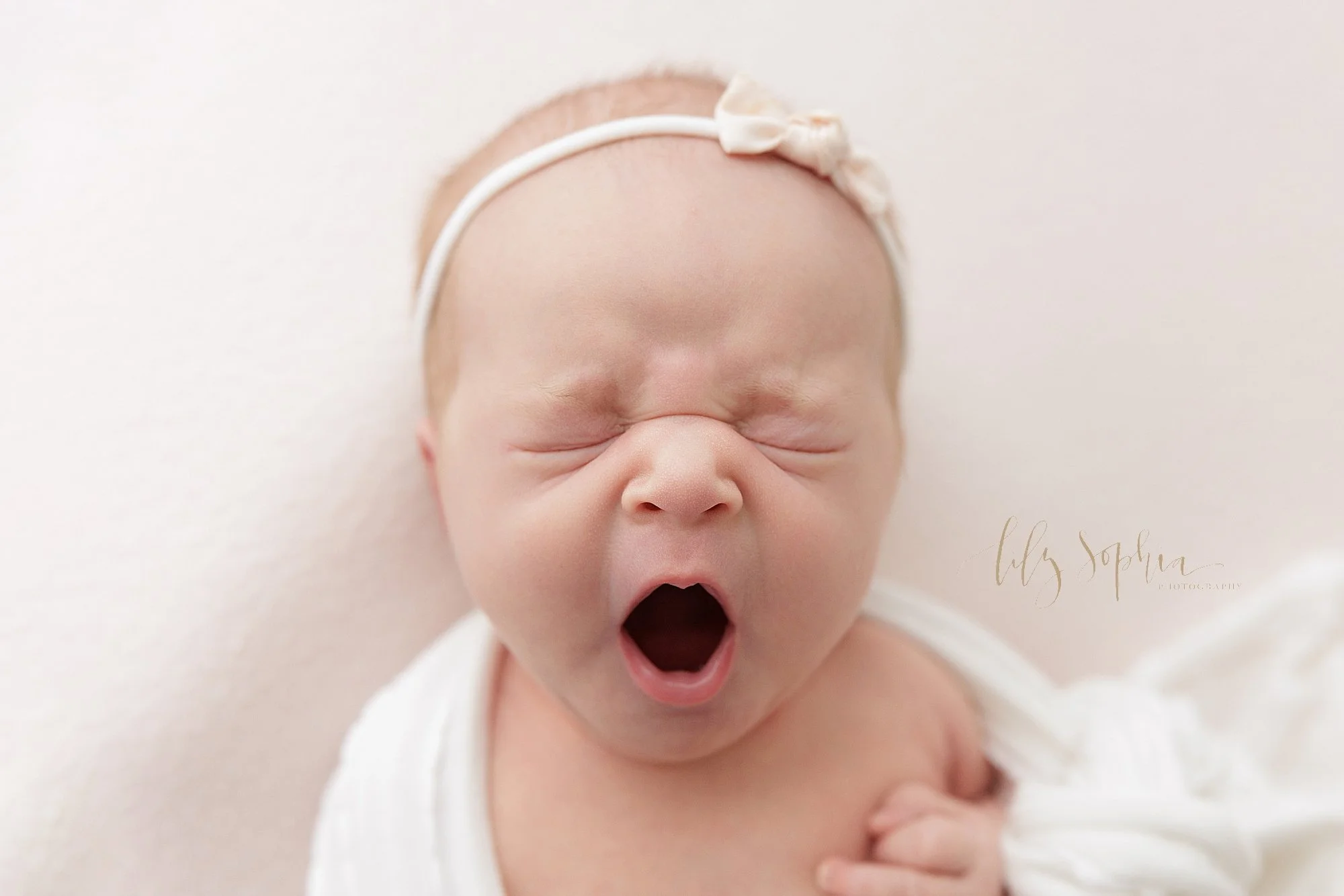  A newborn baby girl’s yawn is captured during a photography shoot in a studio that uses natural light near Old Fourth Ward in Atlanta, Georgia. 