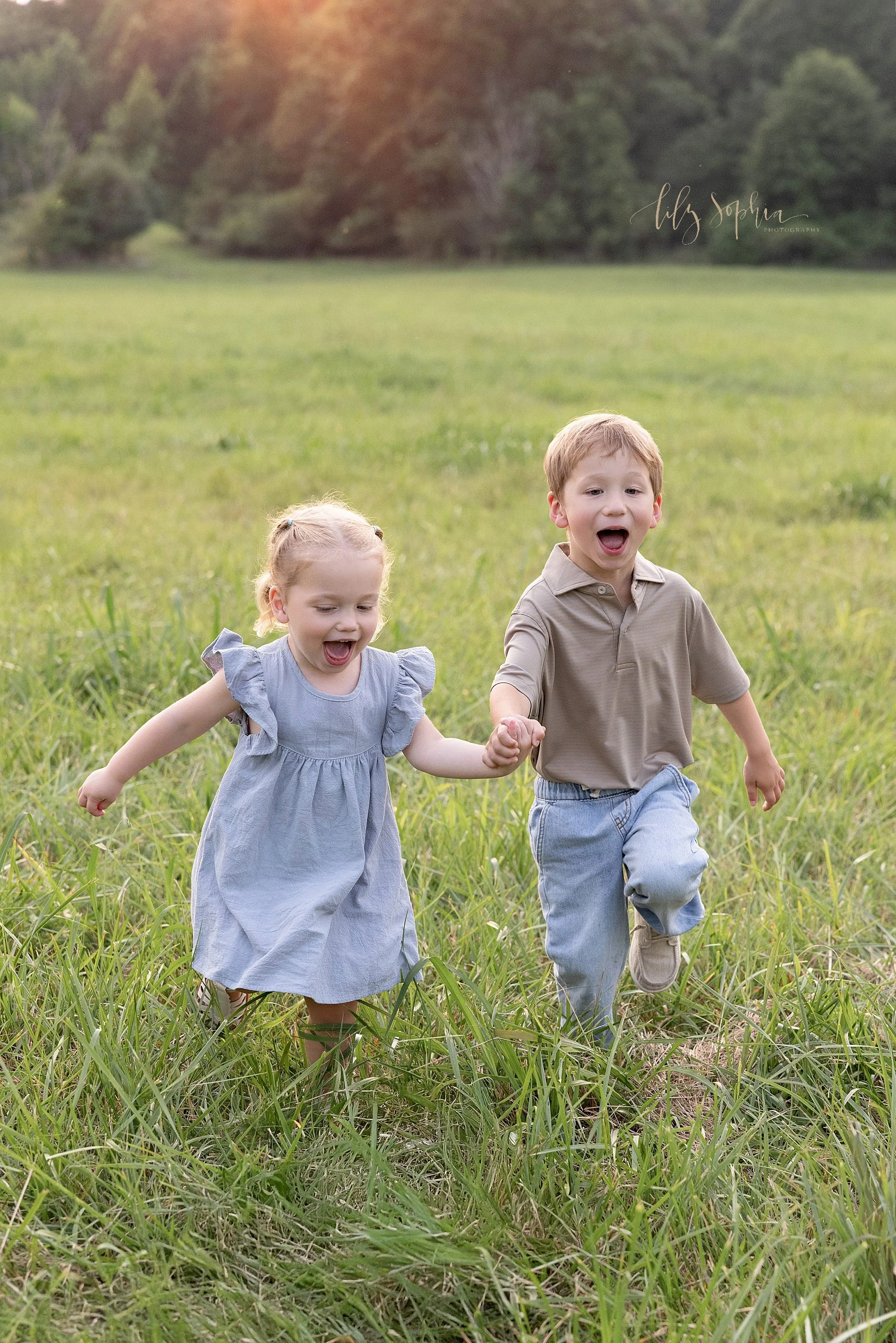  Family photo of siblings running through a field near Atlanta, Georgia at sunset during a family photography session. 