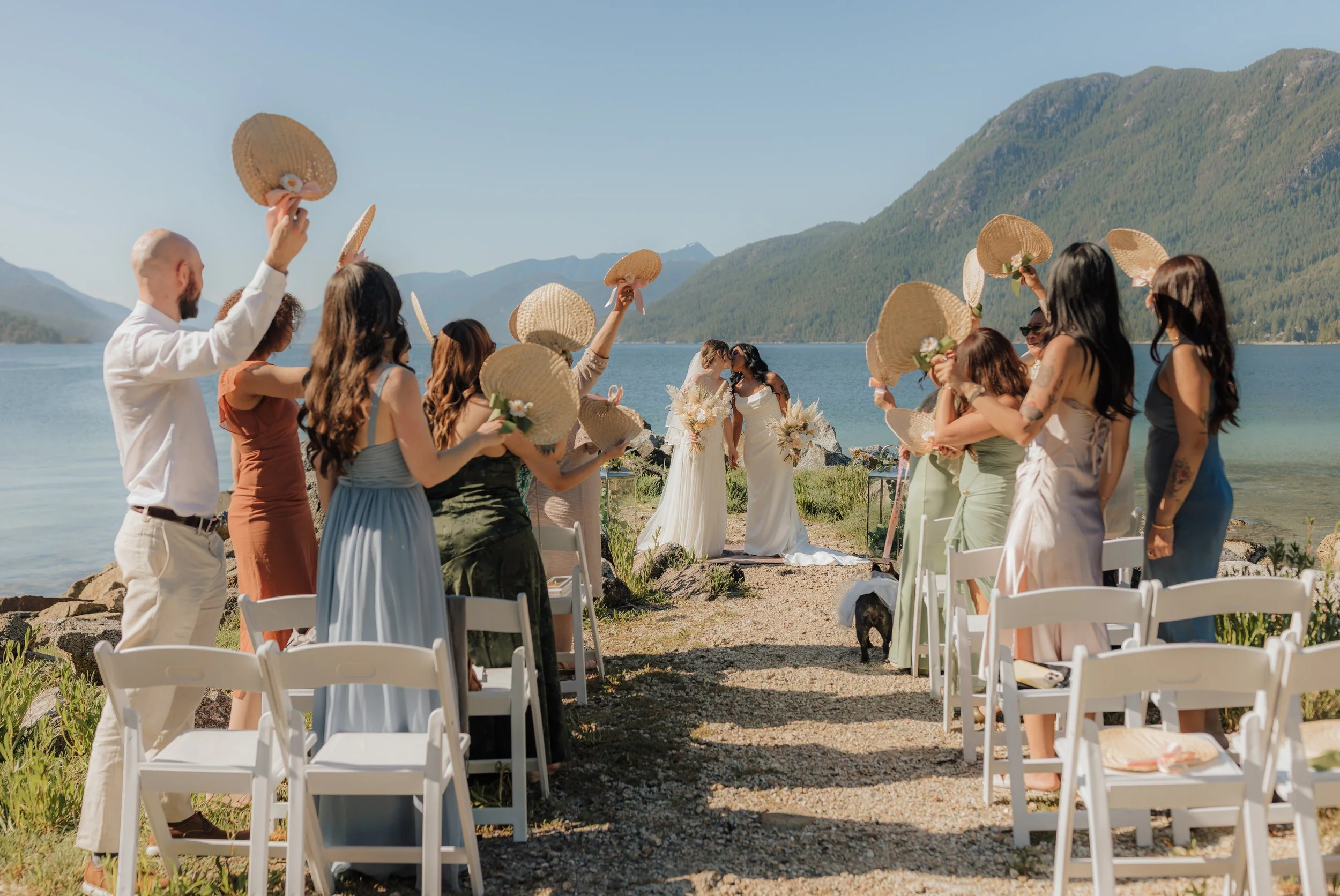 group of friends and family celebrating with the wedding couple with mountains and ocean backdrop on the Sunshine Coast, BC