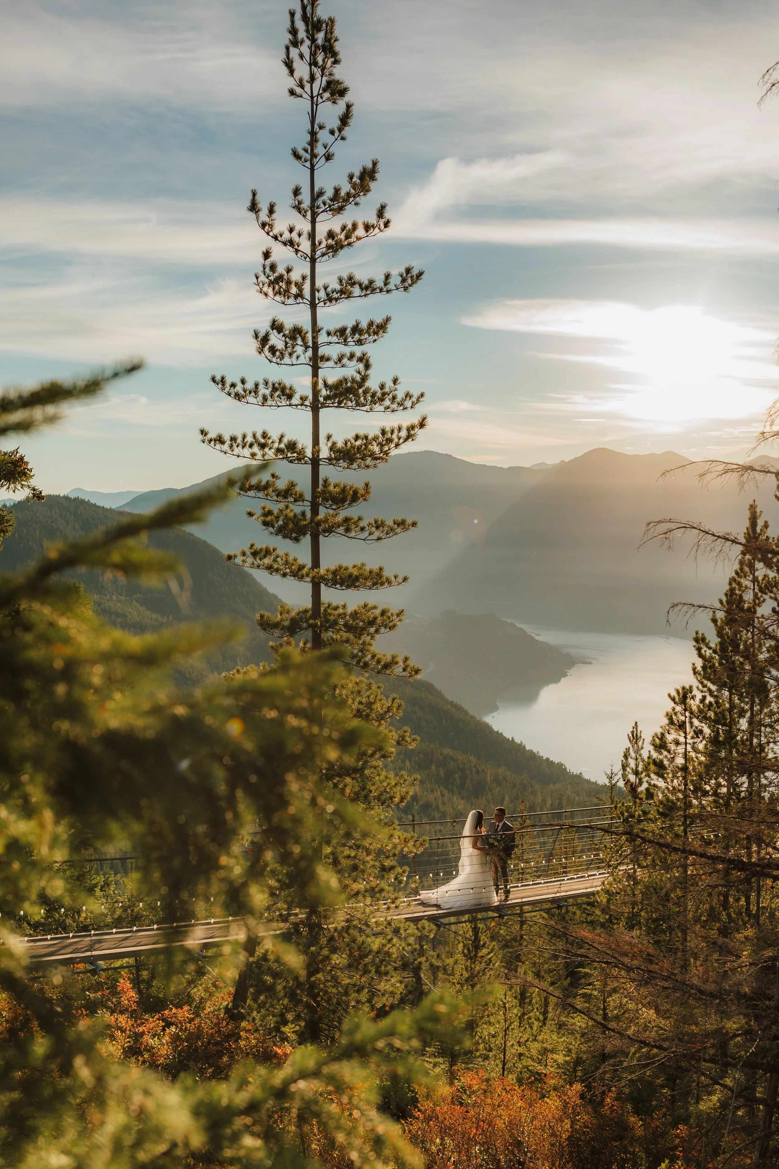 wedding couple standing on suspension bridge at the Sea to Sky gondola in Squamish, overlooking the ocean, forest and mountains