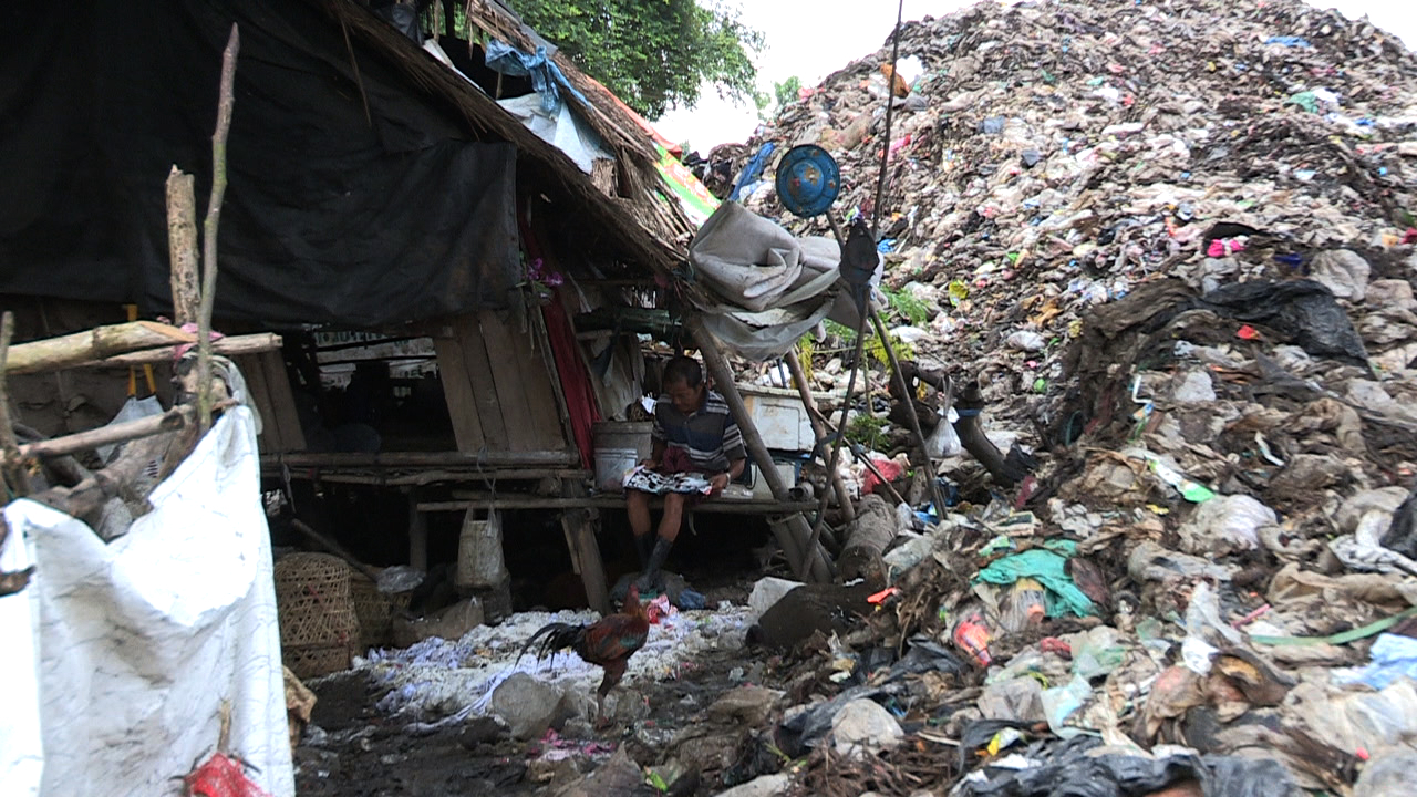 Families live beside rotting, stinking garbage that often threatens to engulf them