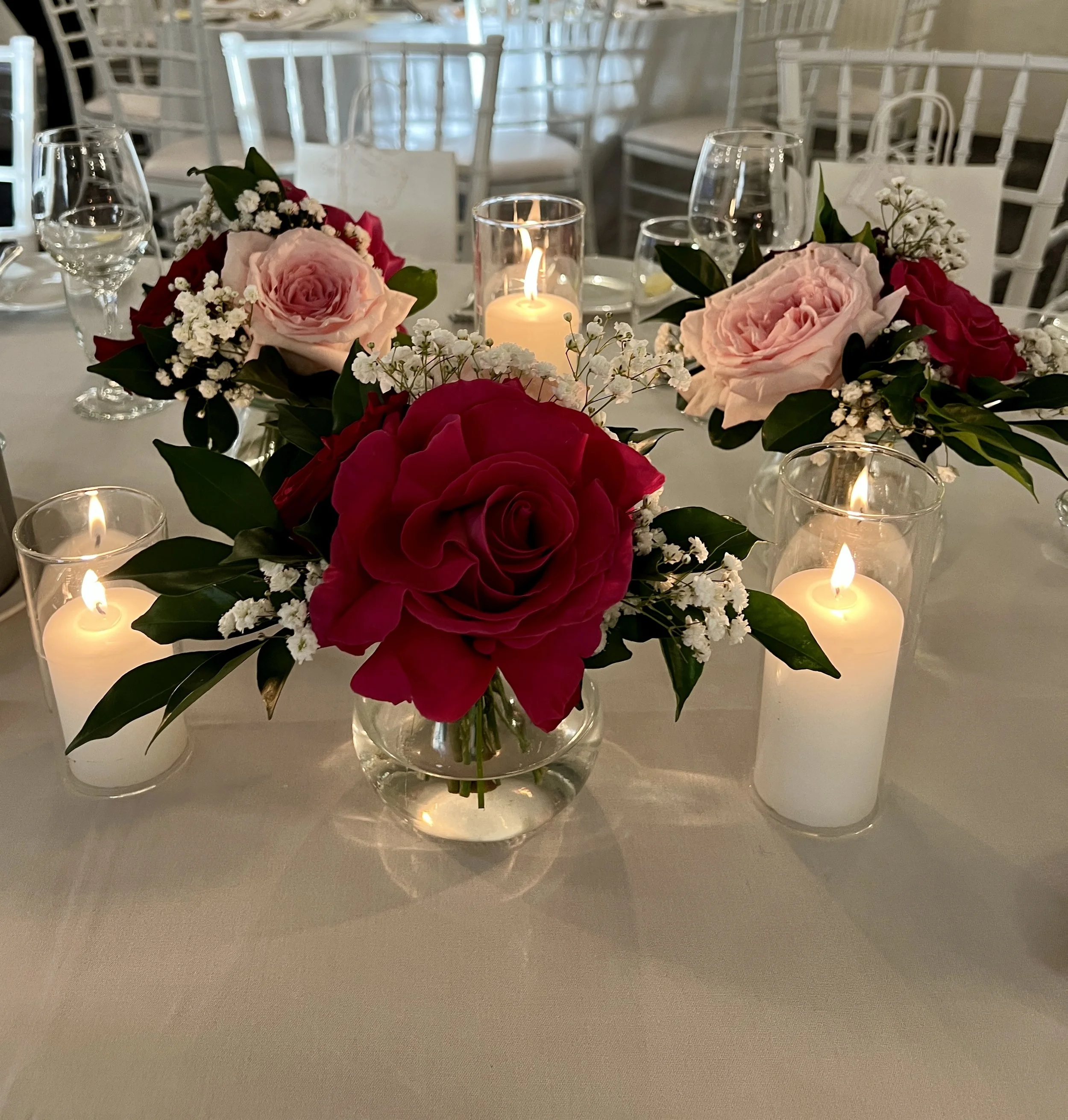 mini vases with pink and burgundy and pink flower posies and candles centrepiece – Sydney wedding flowers by Lovely Bridal Blooms