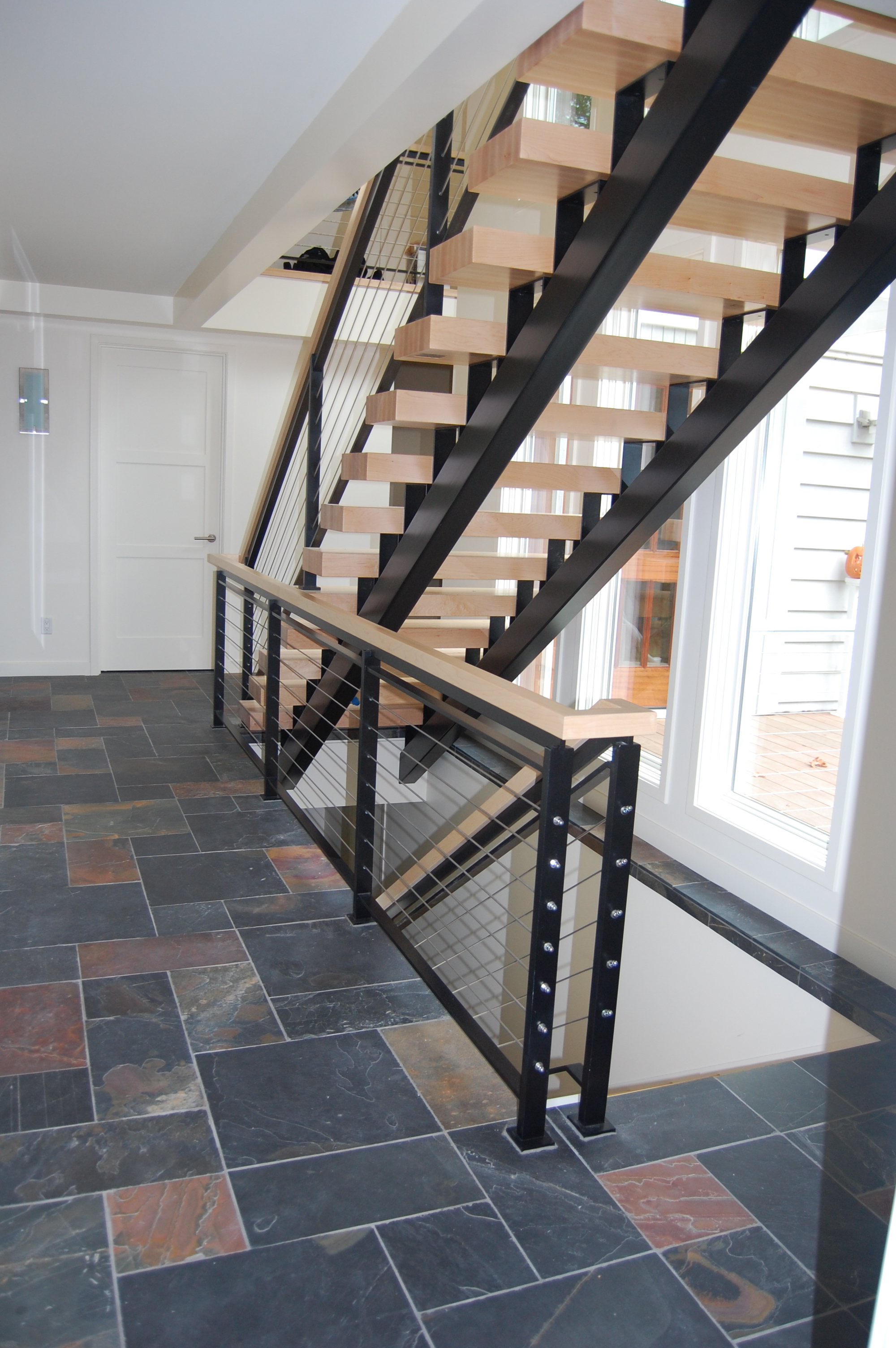  Staircase built out of steel with flat bar cable railing.  Designed by MCM Construction 