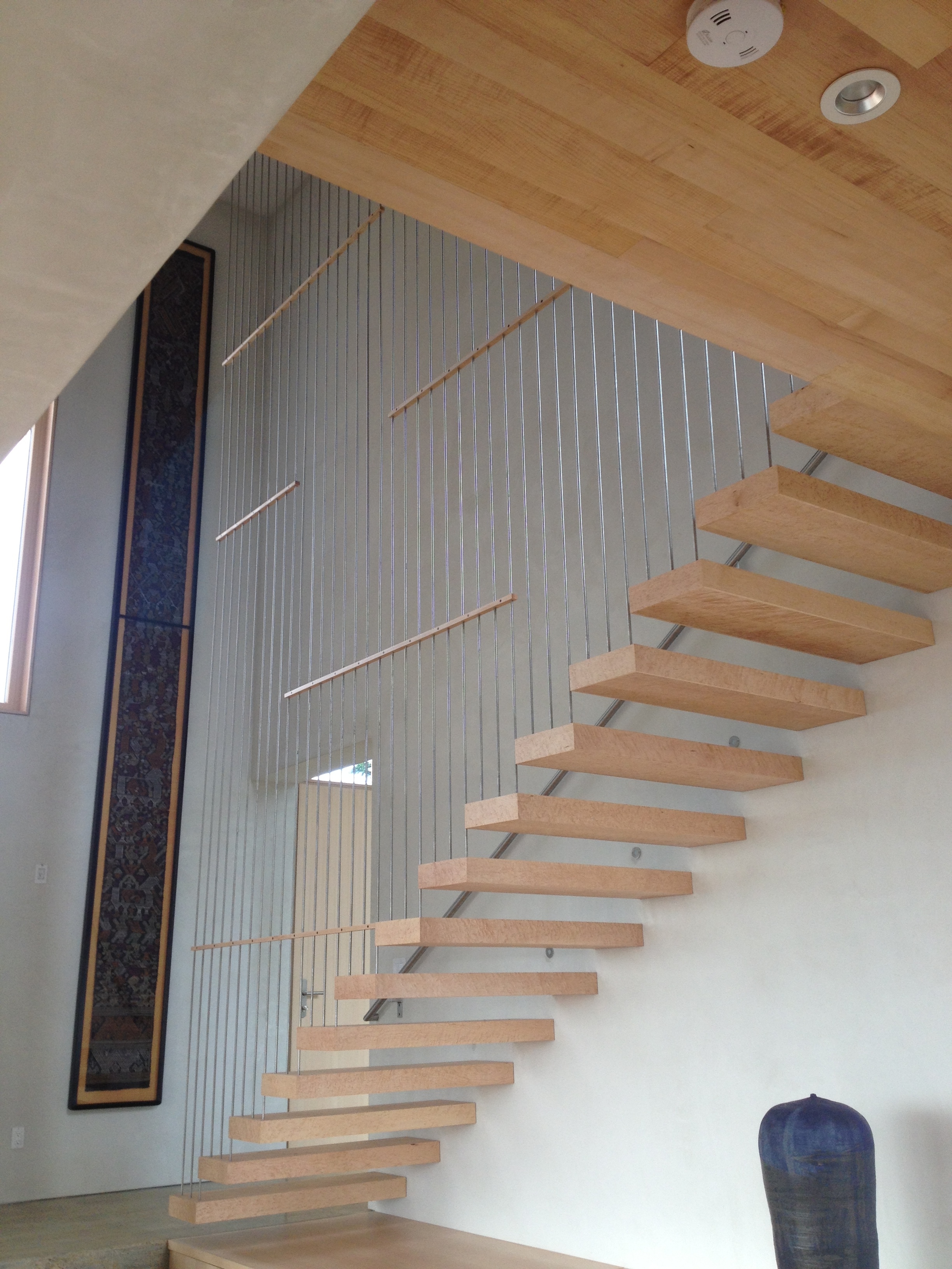  Steel plates that were bolted into the wall and hidden in the wood treads. We also&nbsp;supplied the stainless rods to help support the stairs and&nbsp;fabricated the stainless grab rail.  Designed by Holst Architecture 