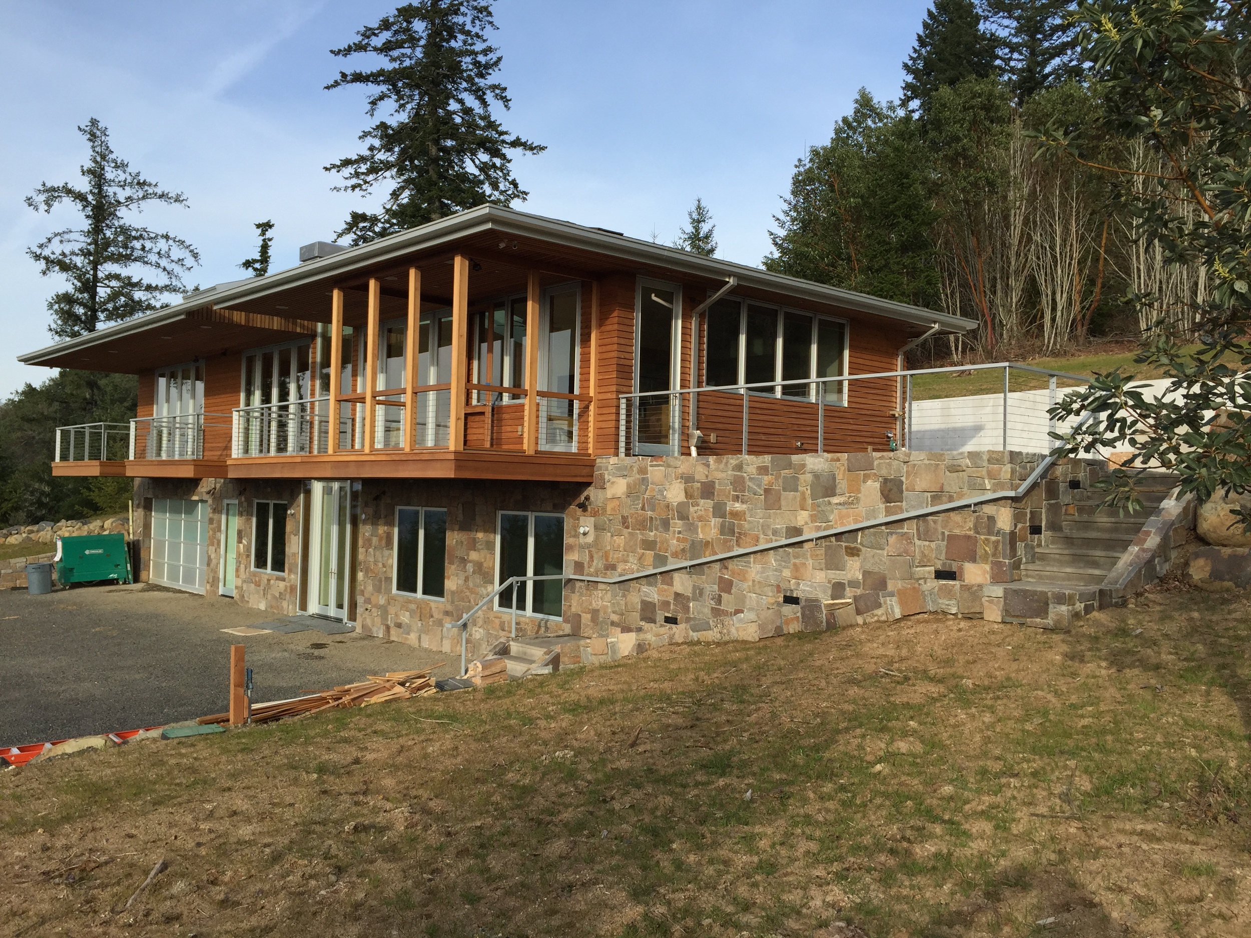  3 decks and a stone wall with steel railing with stainless cable infill.  Designed by Pete Retondo Architecture 