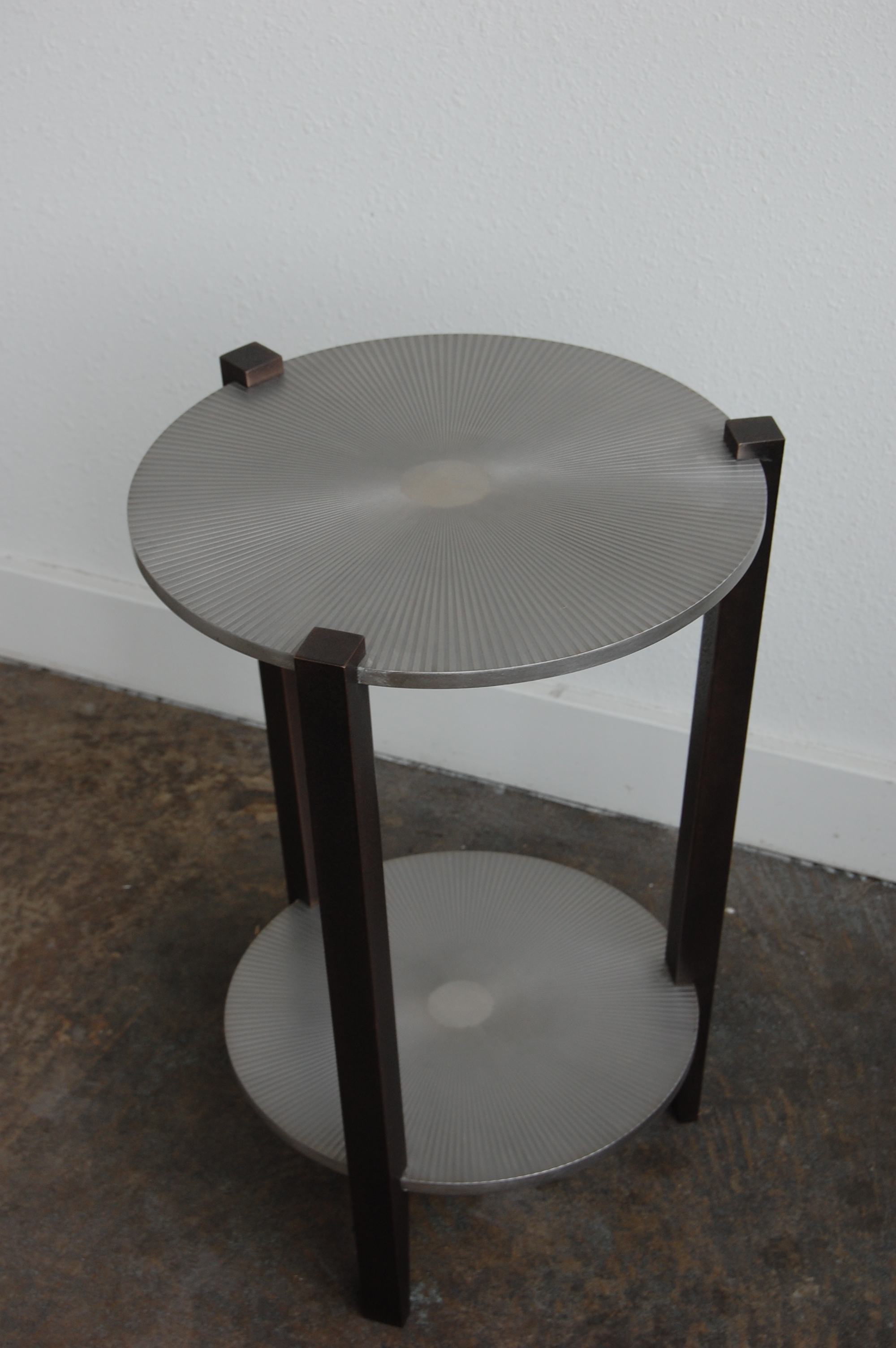  Stainless steel with starburst etched pattern. Legs are textured bronze.  Designed by Formed Objects 