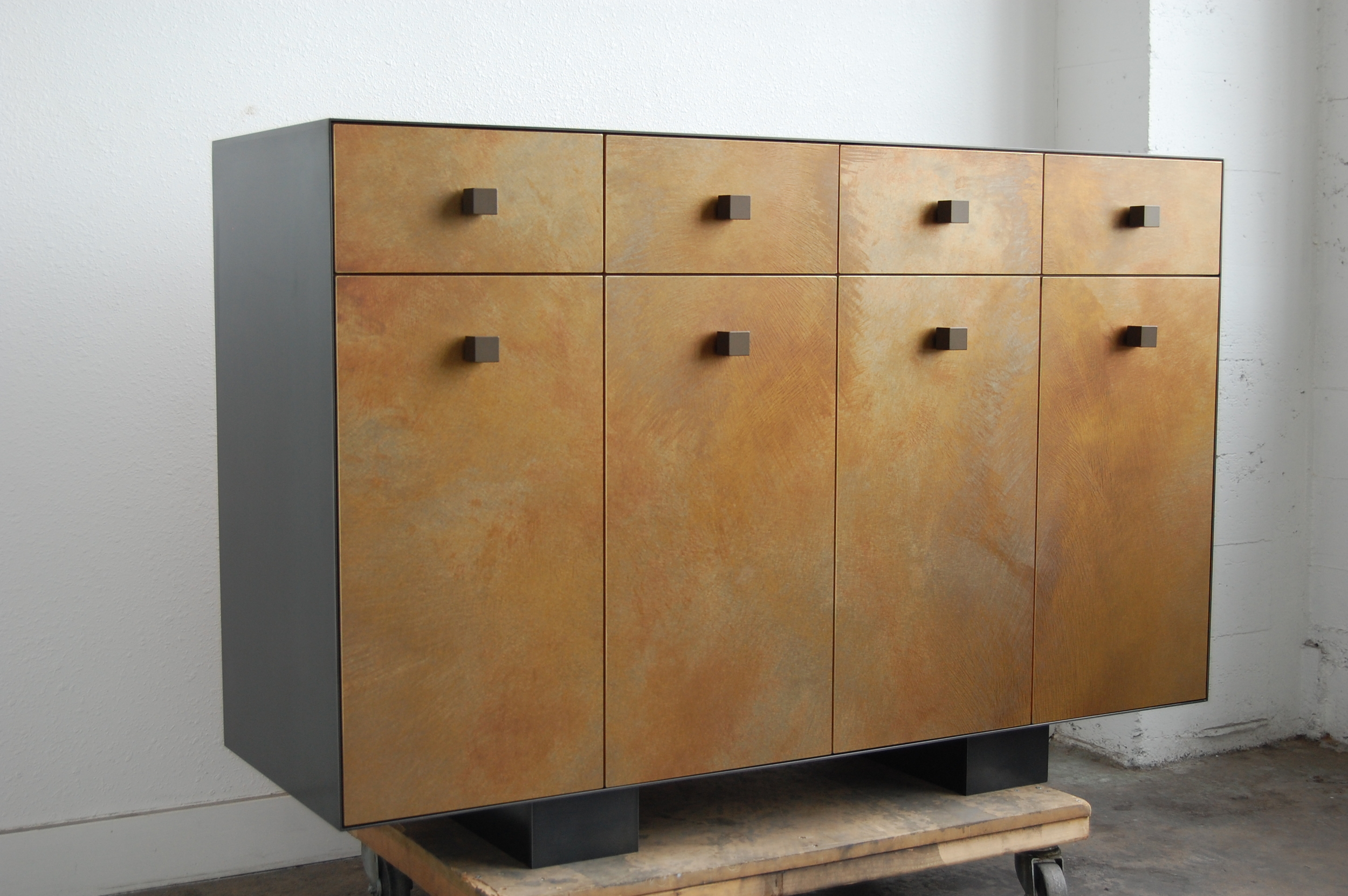 A wood cabinet that is clad in Hot Rolled Steel and brass sheet with patina.  Designed by Hensel Design Studios 
