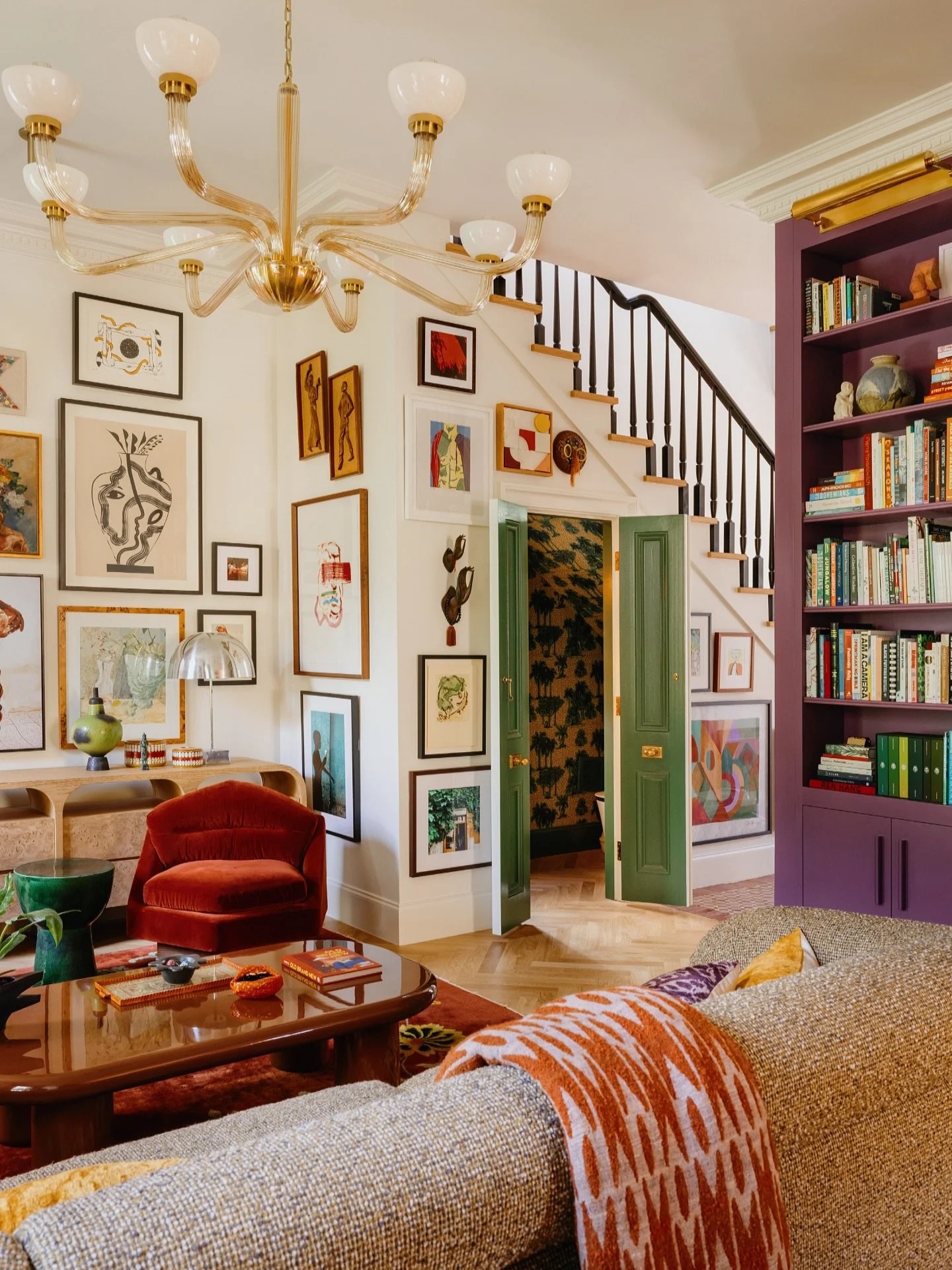 Living room reveal! This angle gives you a look at how we maximized every inch of our double gallery side hall, including the powder room tucked right under the staircase to make use of that space. We installed dentil crown moulding and custom built-