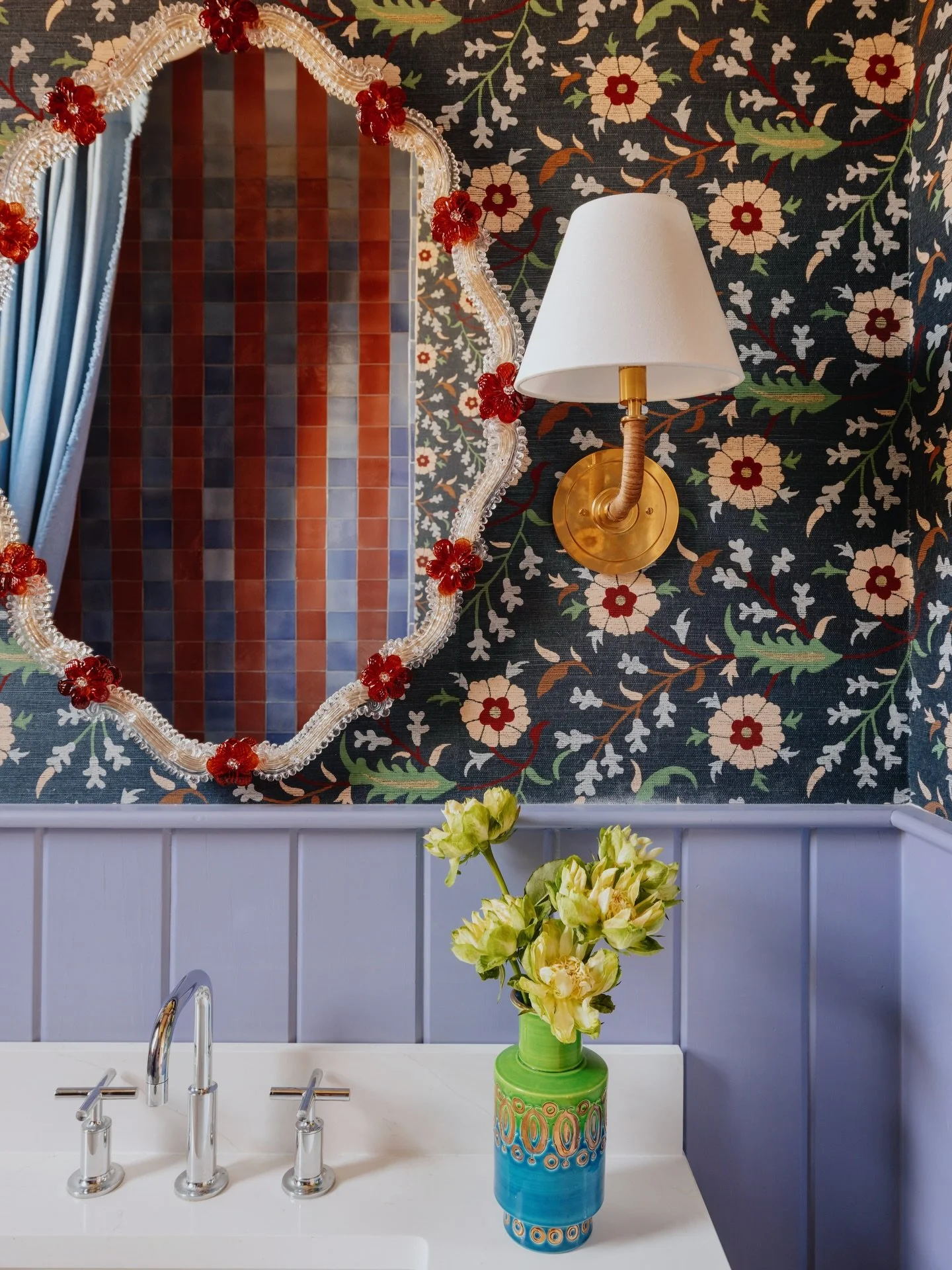 Our guest bath is a full-on embrace of maximalism. Striped tiles meet floral sisal wallpaper, tongue and groove wainscoting, and Italian Murano glass. It&rsquo;s a sensory overload in the best way possible. While it might be too much for some, seeing