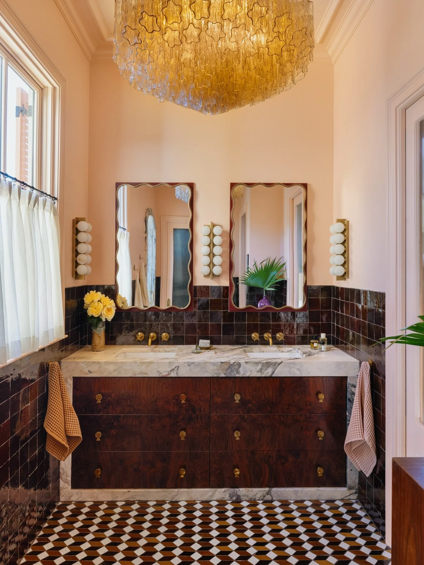 We definitely went big in the primary bathroom. It&rsquo;s a study in opulence and maximal restraint, leaning into the organic texture of Zellige mosaics grounded by a custom burlwood and marble vanity. I was tired of dim bathrooms, so I made sure th