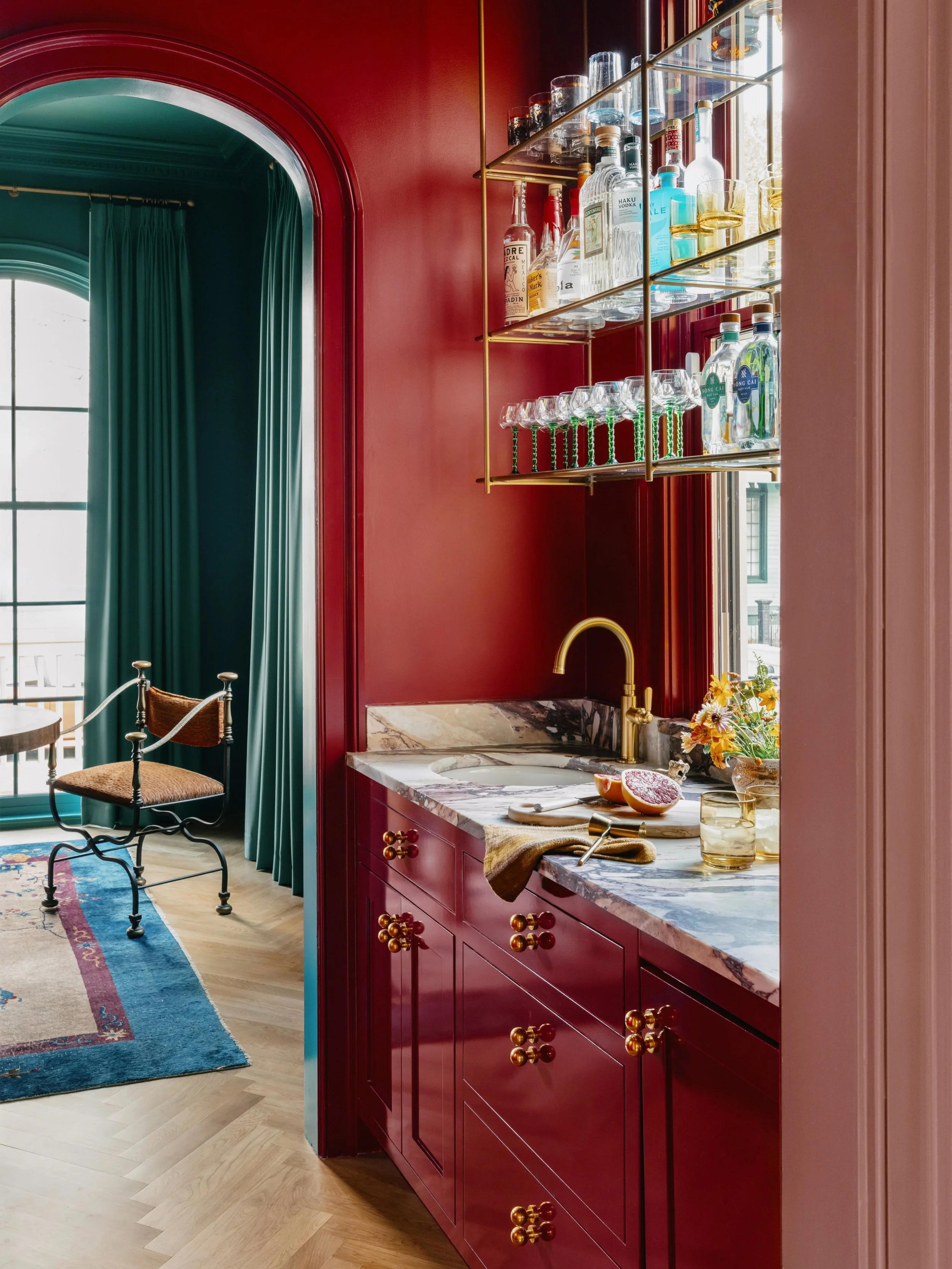I love playing with hardware placement to make a space feel truly custom. For the wet bar, I stacked @Emtek_Products globe knobs vertically against that bold, high-gloss red. For the cottage cabinets, I paired up their classic egg knobs on every draw