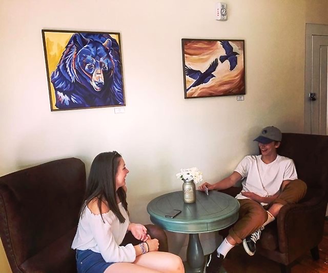Mon Vert Cafe patrons chat beneath two original paintings, Woodstock, VT, 2017