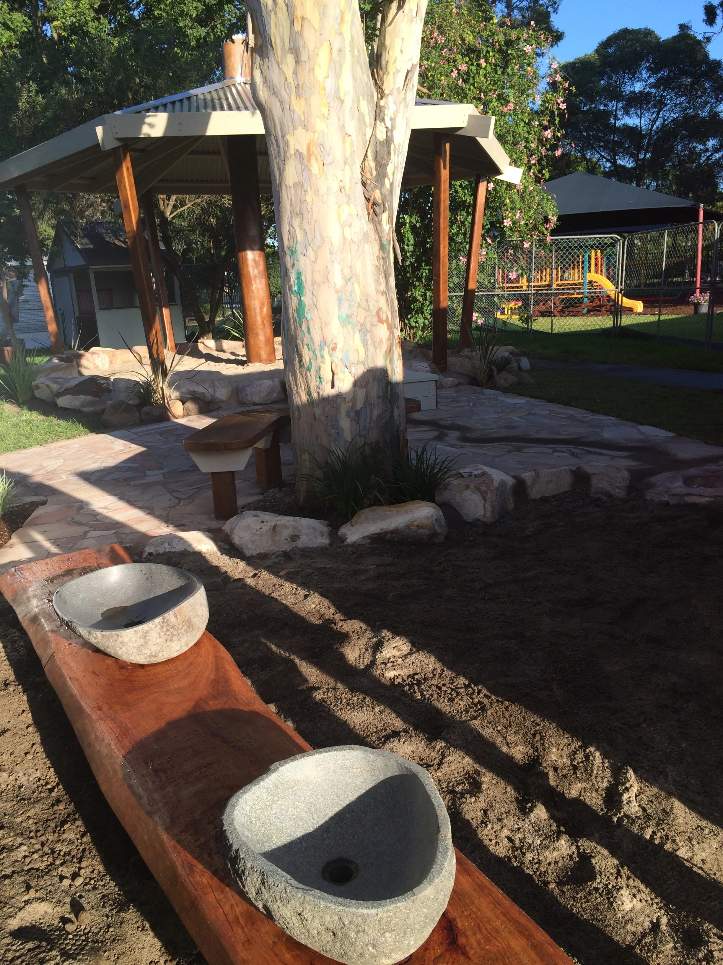 Looking back now from the Mud-pit to the Water Course and arrive at the transformed Sand-Pit. Look at the beautiful stone bowl with drainage into the mud-pit and seating for adults and children alike