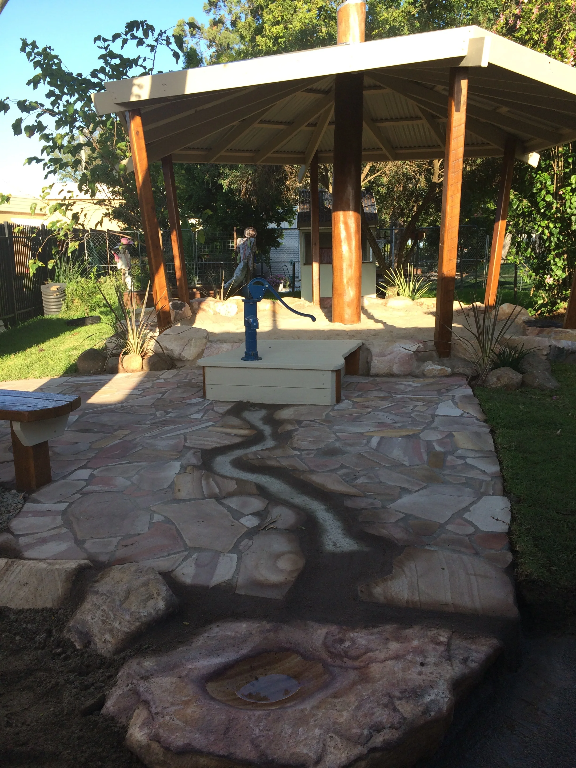 This Hand water Pump has a Under-Ground collection Tank that is connected to the existing Kindies Water Tank. Add easy to maintain crazy-pave Sandstone and Wellah fun for all.