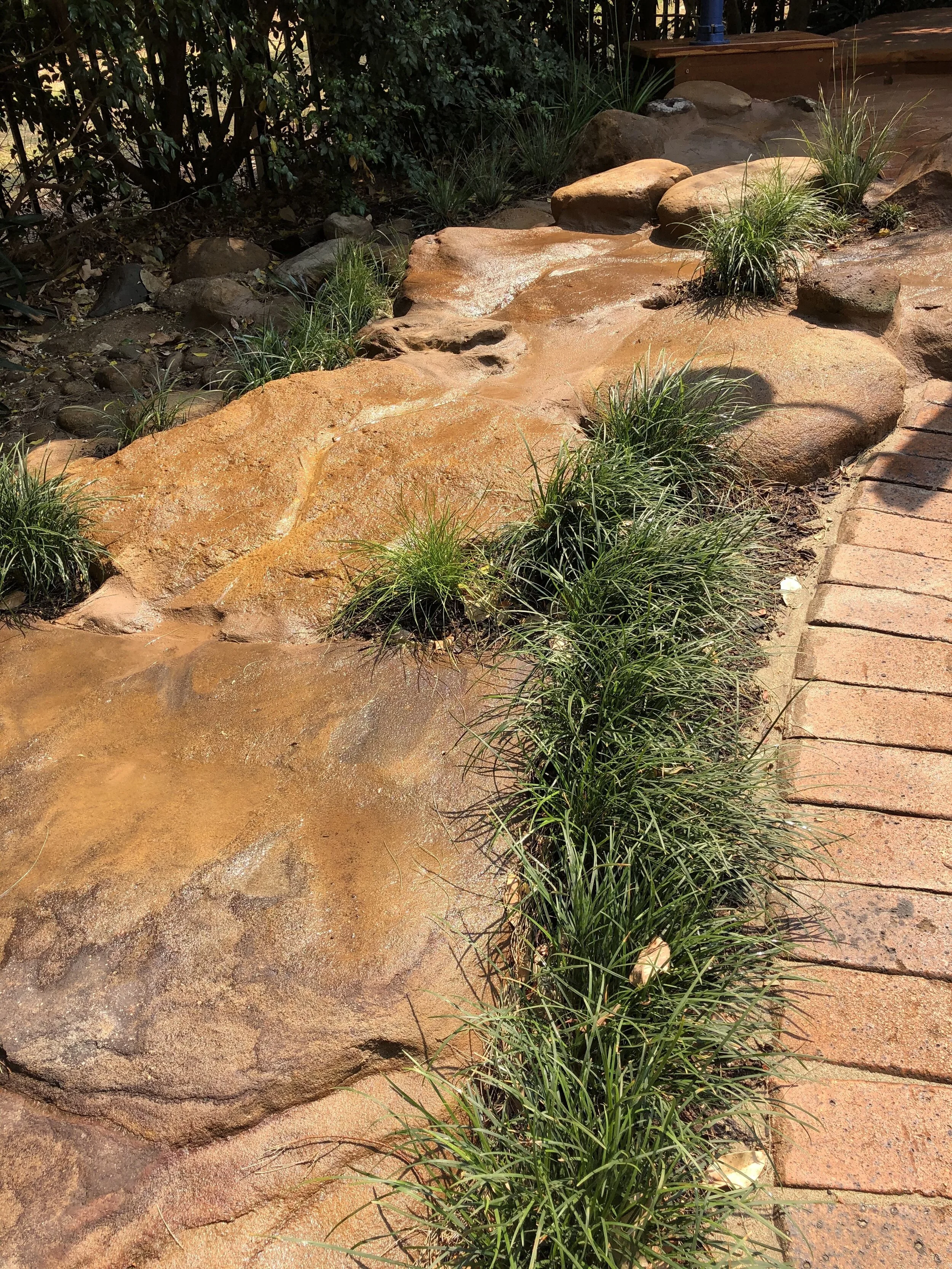 River stone slab water course to a mud kitchen