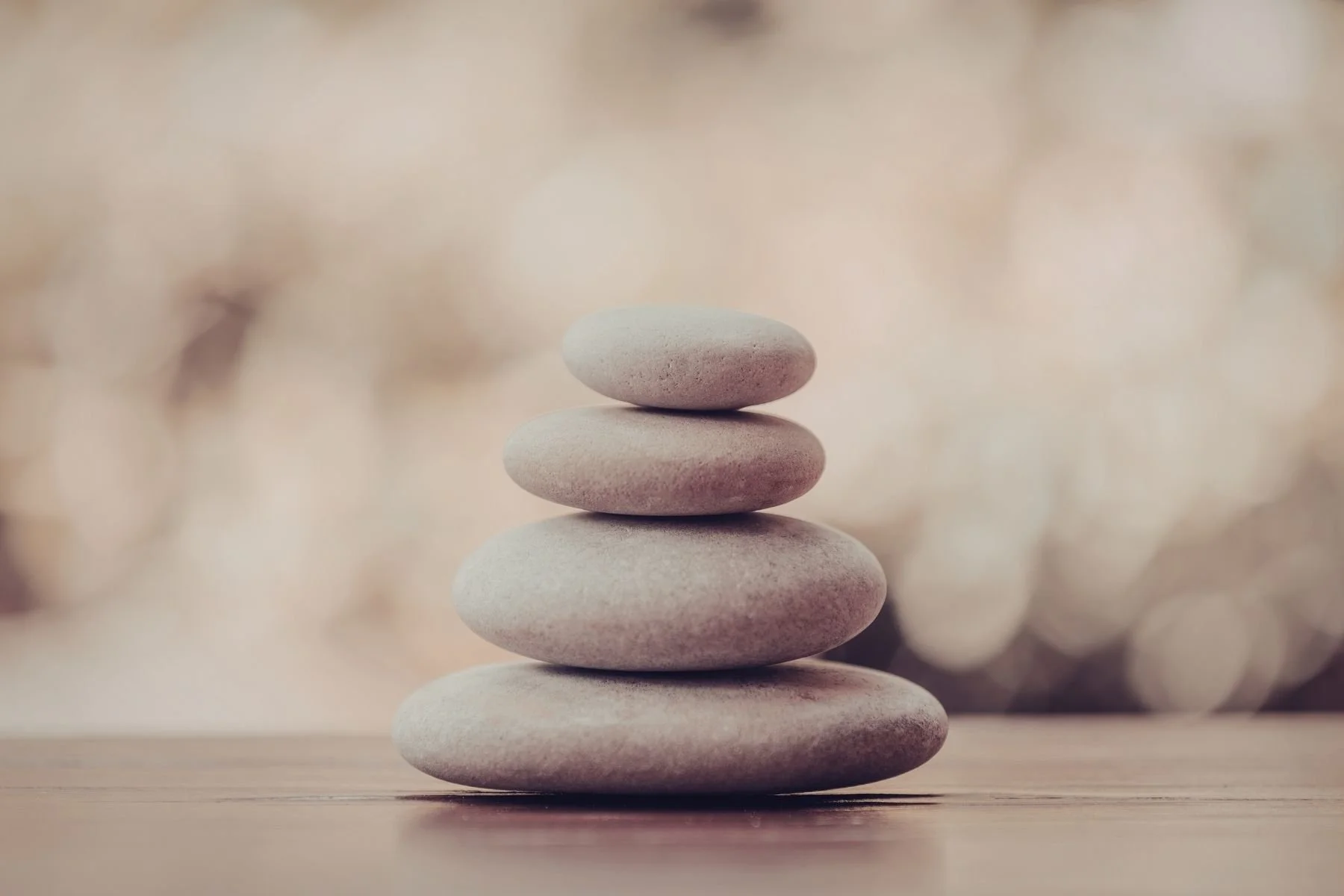 Stacked smooth, rounded stones with a blurred bokeh background.
