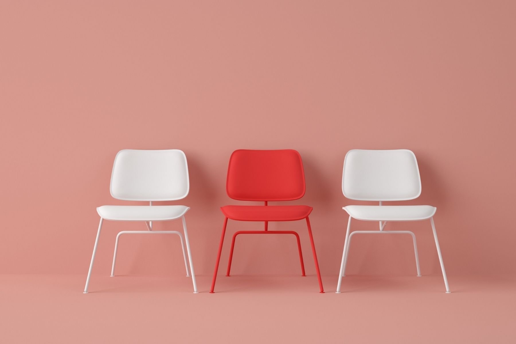 Three modern chairs with metal frames, two white on each side and one red in the middle, placed against a pastel pink background.