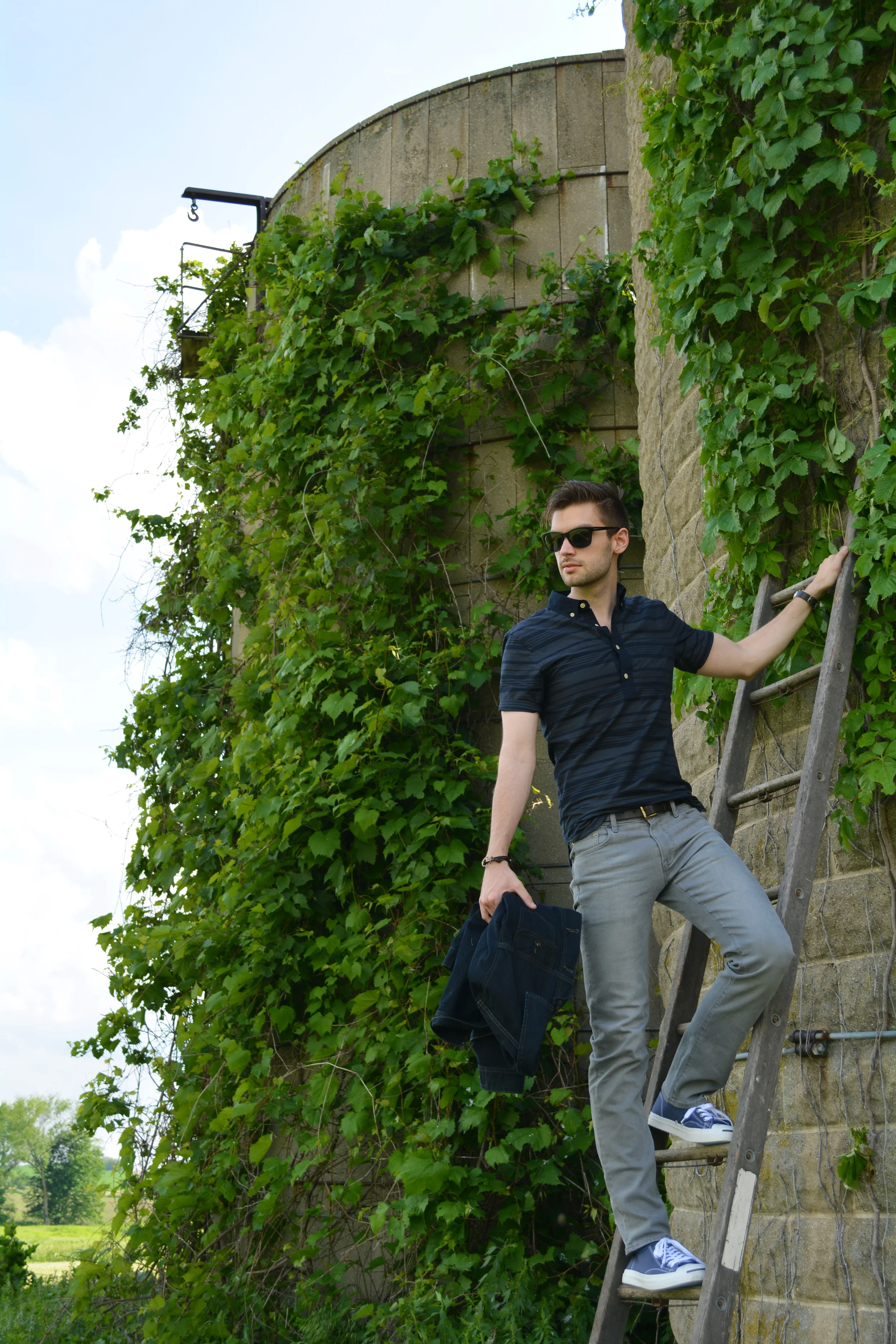 You can take the boy out of the City, but you can't take the City out of the boy. The rolling green hills and wheat fields were a perfect break from NYC but you can't separate me from my dark muted tones. I've got concrete in my DNA! Time to truck it back to the Big Apple! I'm starting to get on board with popover button down shirts. I was against them for so long but with the right colors and pattern they're like a refined polo. They are a nice break from the conventional during these Summer months. Just make sure you find one that's fitted so it doesn't look like a smock. Tuck a bit of the front into your belt and let the rest hang out for a relaxed look--- perfect with denim or trousers. Vacation is over! Time to get back to the grind! ;) Photo Credit: SW Club Monaco popover shirt / Uniqlo denim / Lucky Brand denim jacket ( similar ) / Jack Purcell sneakers / Nixon watch / Maritime Supply Co. anchor bracelet / Banana Republic sunglasses