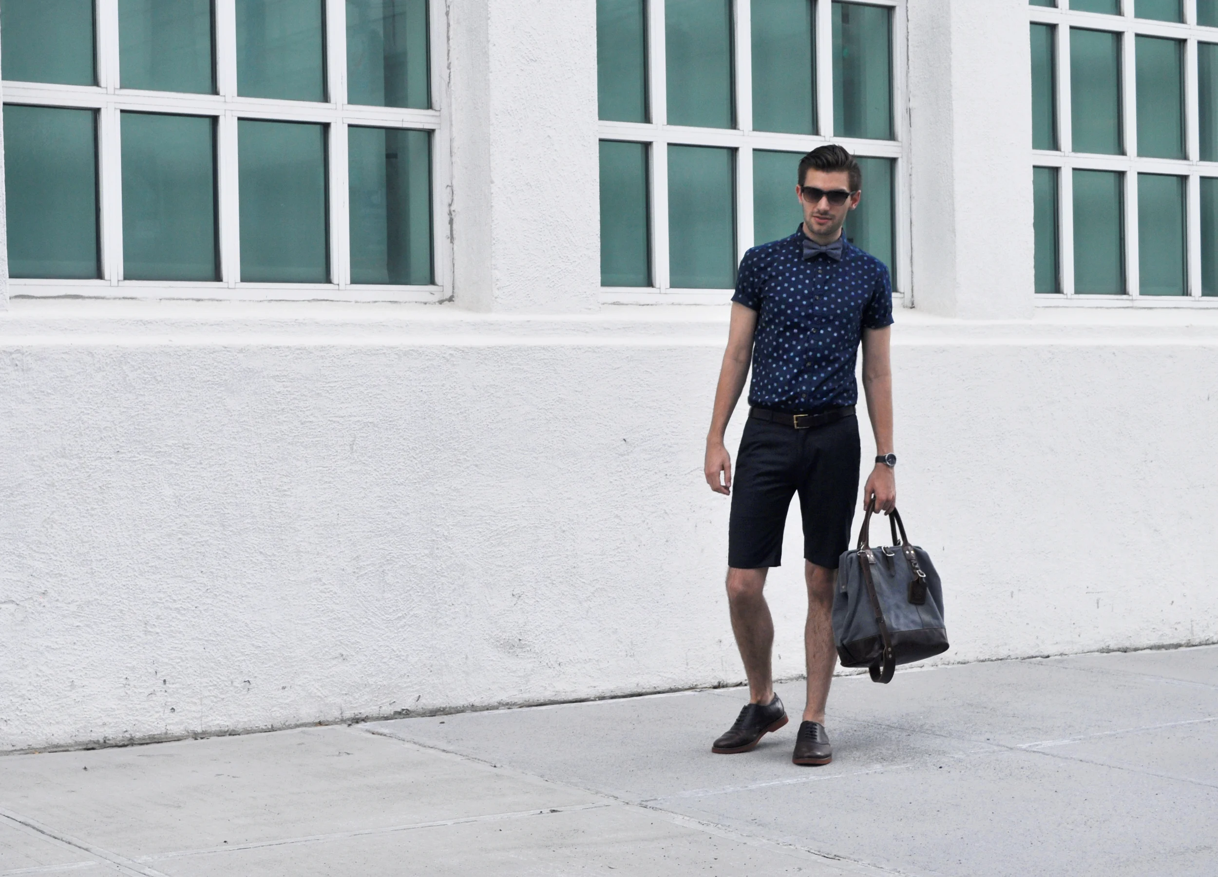 A suit with matching shorts is really only for sartorially savvy men like Nick Wooster. But suiting shorts on their own? I can definitely get on board with! It's a little outside the norm and not really appropriate for the traditional office, but if you work in a creative or non-conservative workplace, give these a try! It's as if you couldn't take the heat of Summer and decided to cut your wool pants off just above the knee. Polished but breezy. Here's a styling tip: Like dress pants, you should continue to wear them with oxfords but ditch the socks (or opt for loafer socks). Stick with a button down shirt, with or without a tie. It's not the kind of short you wear with sneakers and a tee. Shake up those Suits in your office and wear something modern! The Otter sure is... P.S. It's also a great look for daytime weddings and brunches. Just sayin'... What do you think? How would you wear the shorts? Club Monaco shorts (old, similar here and here ) / New Look shirt / American Apparel bow tie / Billy Kirk bag / G.H. Bass & Co. oxfords / Banana Republic sunglasses / Nixon watch